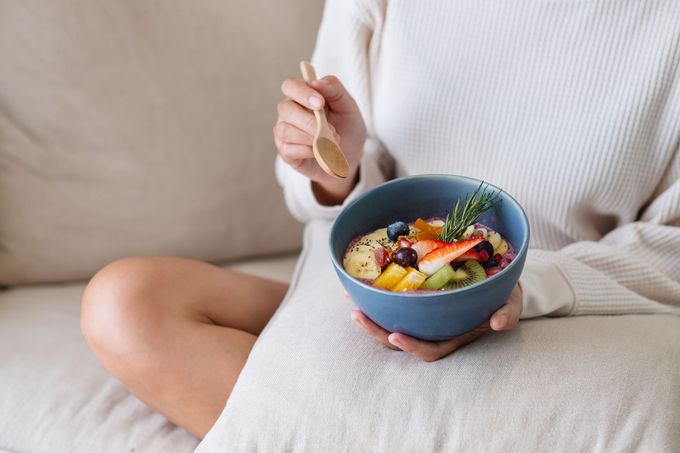 woman eating a healthy smoothie bowl