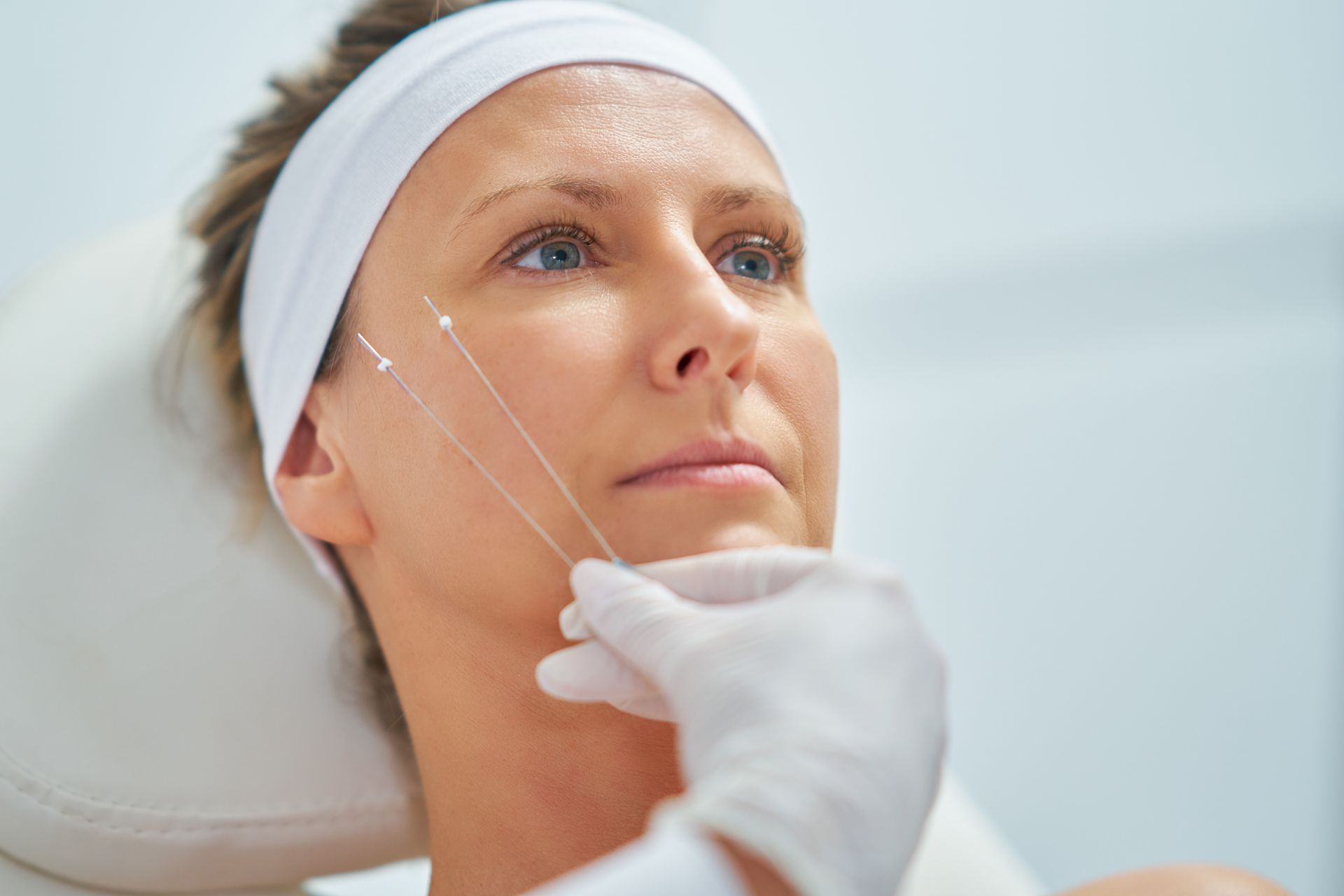 a woman is getting a needle in her face