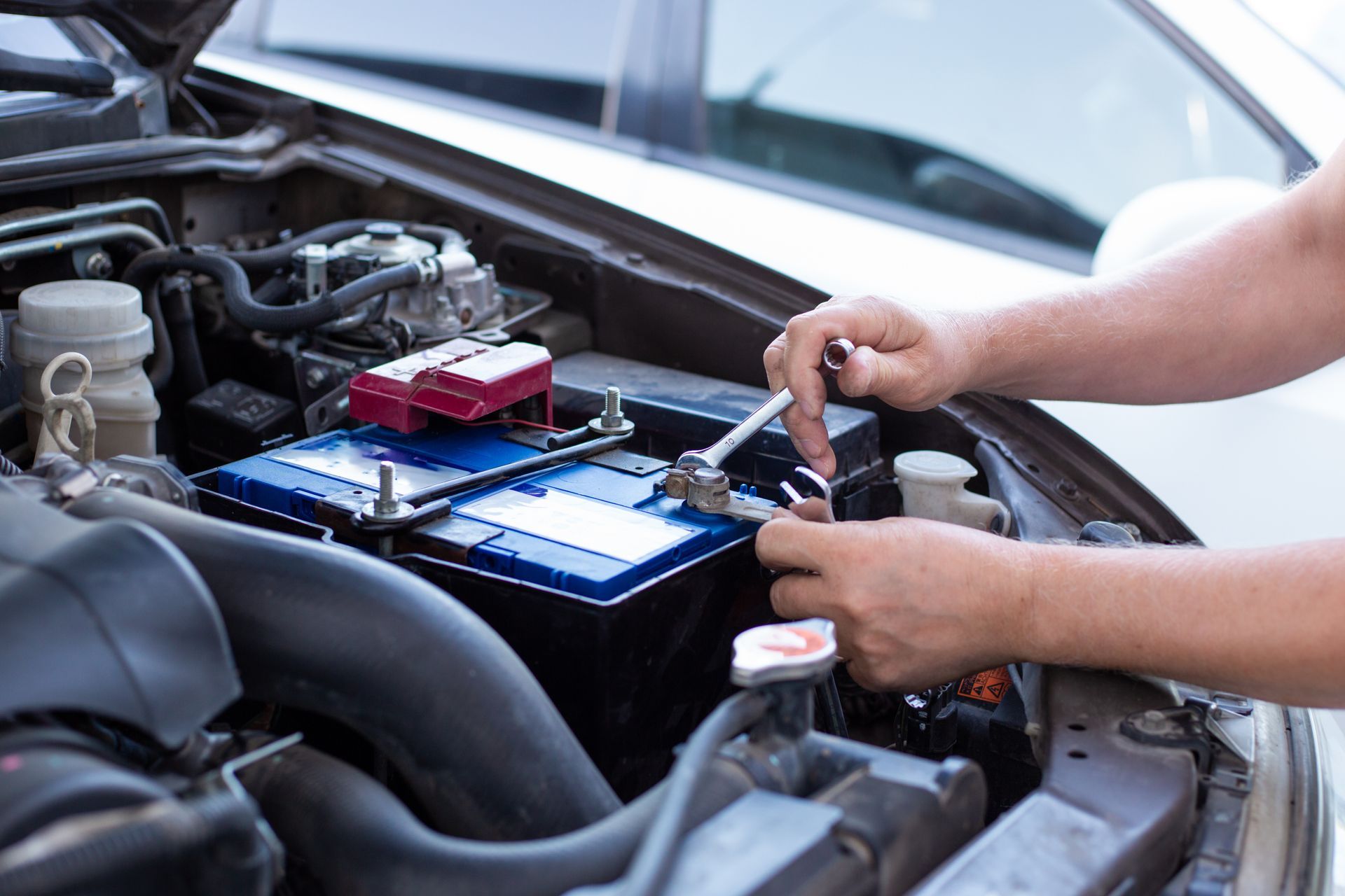 Mechanic replacing a car’s front brake rotor and caliper in a garage
