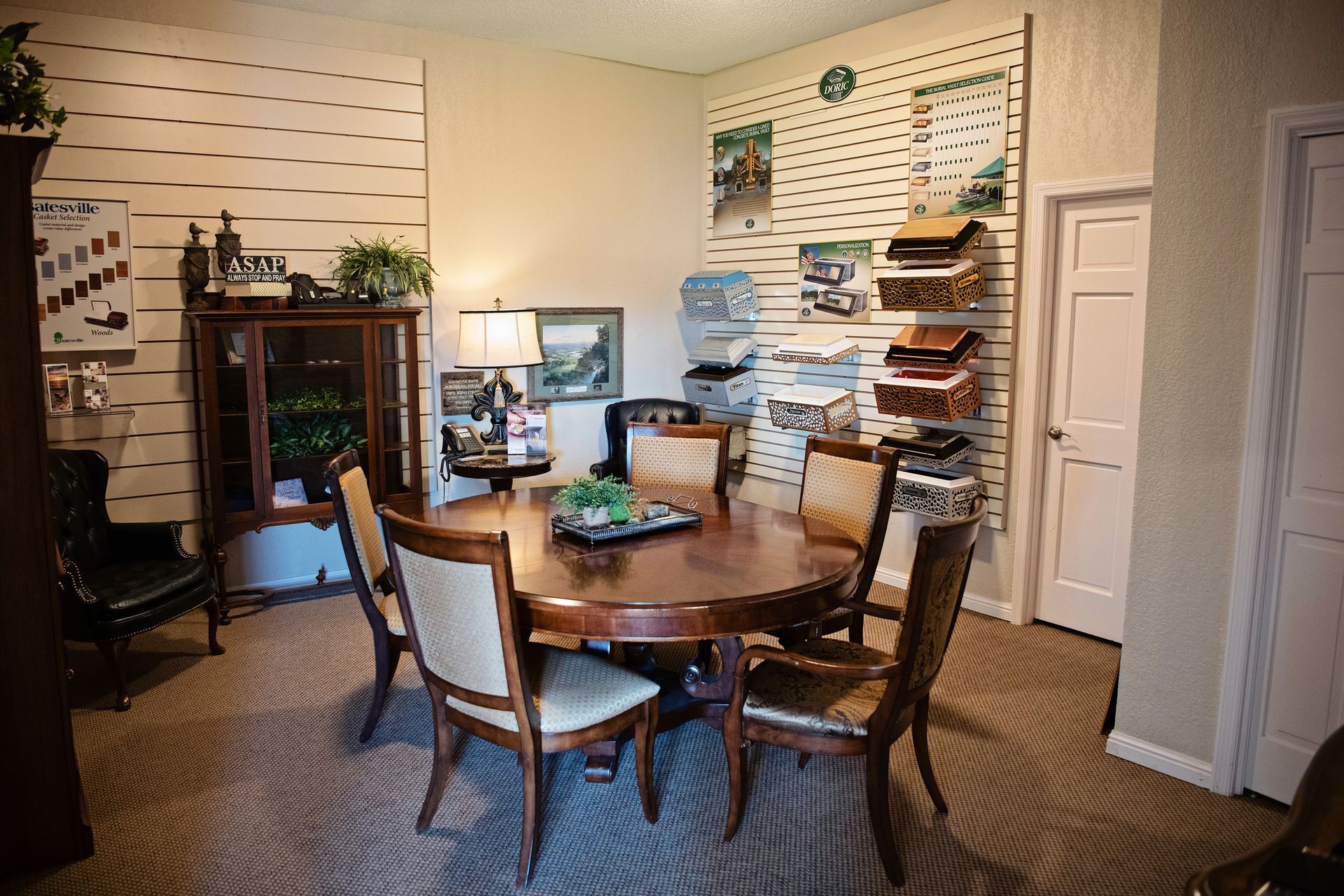 Home office with round table, chairs, computer monitor, and shelves lined with storage boxes.