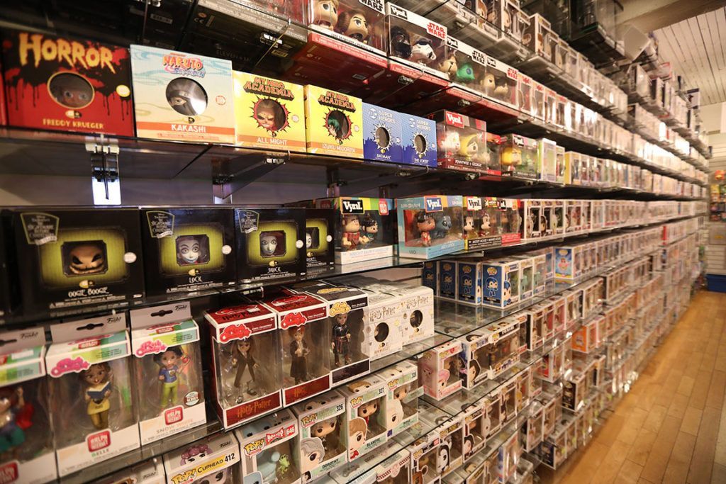Shelves packed with Funko Pop figures in a store. Many boxes visible, diverse characters and themes.