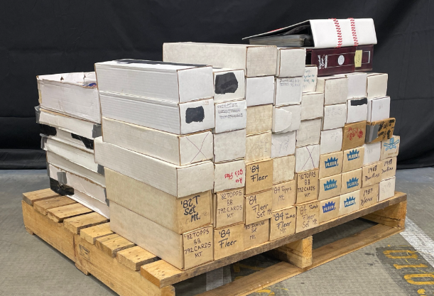 Stack of white and tan boxes, possibly for storage, on a wooden pallet.