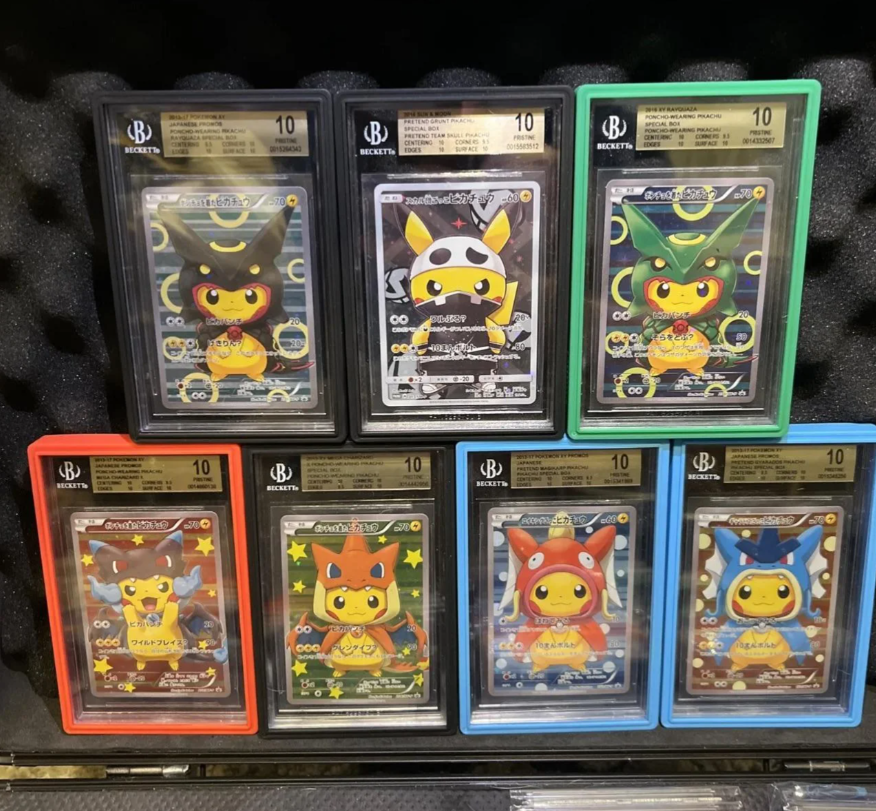 Graded Pokémon cards in colored cases. Pikachu in various costumes, displayed on black foam.