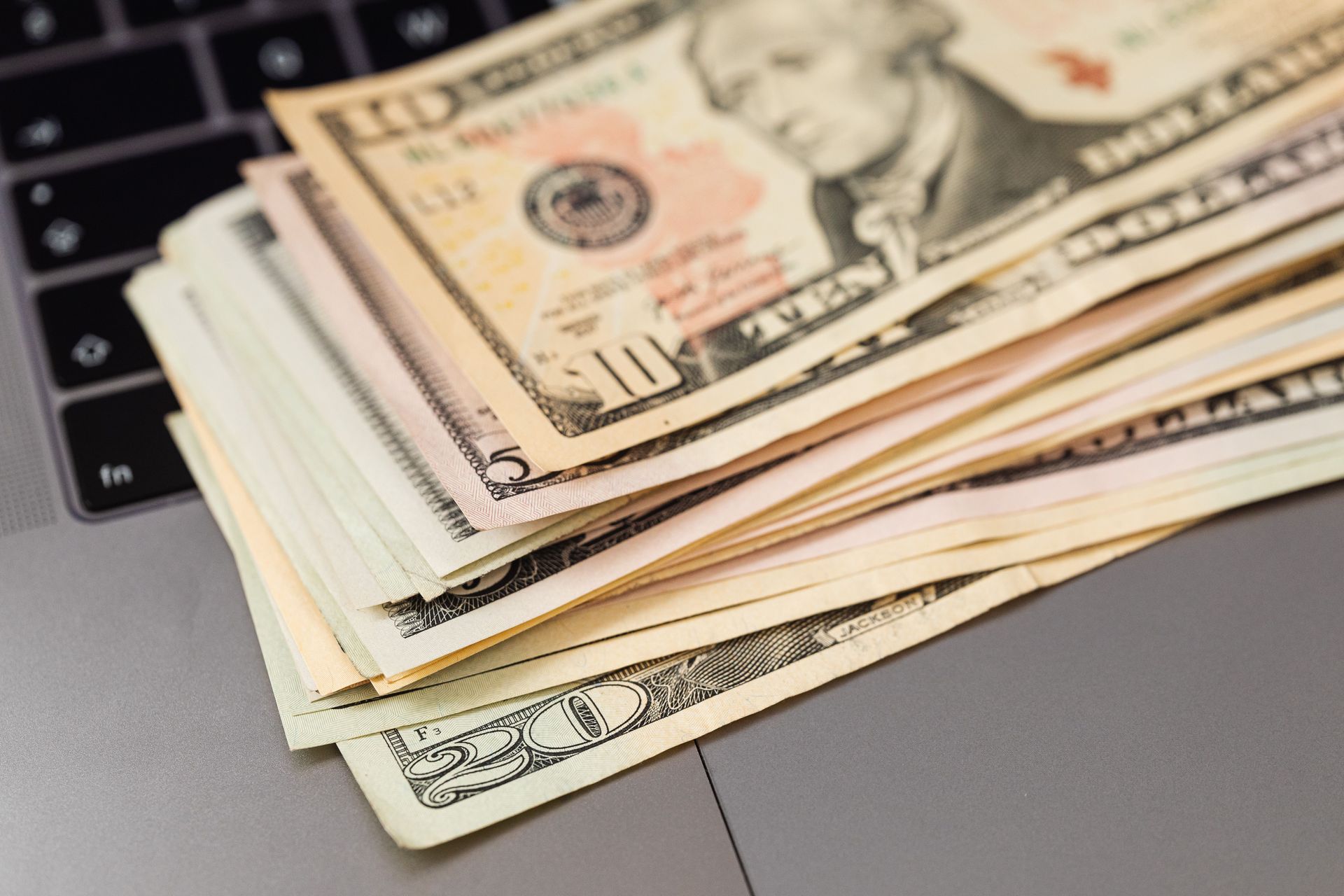 Stack of U.S. dollar bills on a laptop keyboard