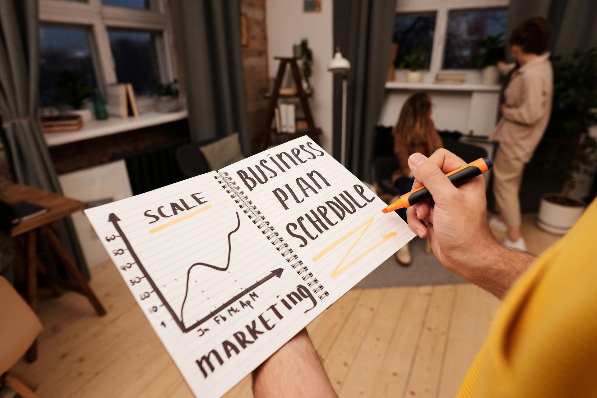 Person highlighting a business plan diagram labeled 