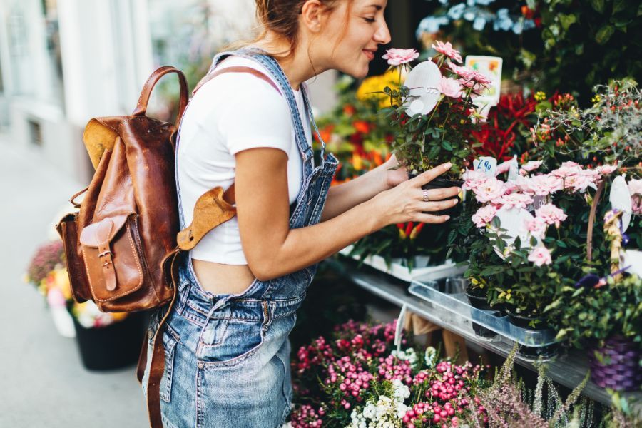 Donna che annusa i fiori esposti