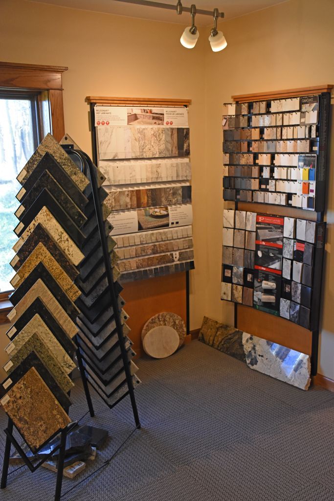 Showroom with carpet samples on racks and display boards under warm lighting