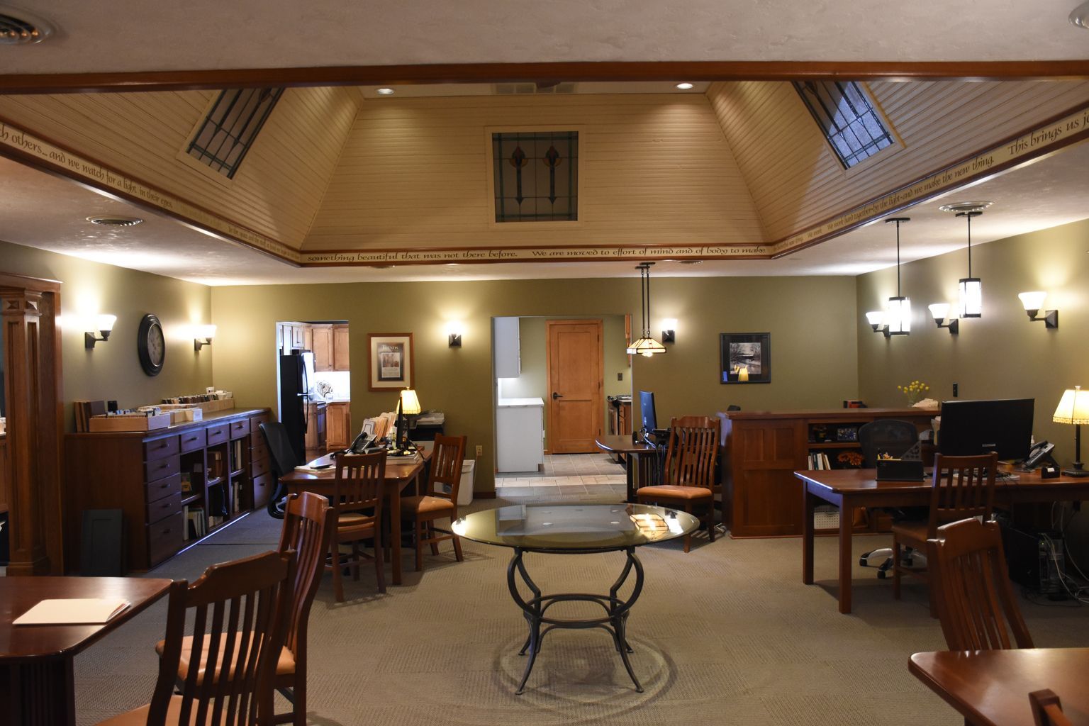 Elegant dining room with wood tables, chairs, wall sconces, and a high vaulted ceiling