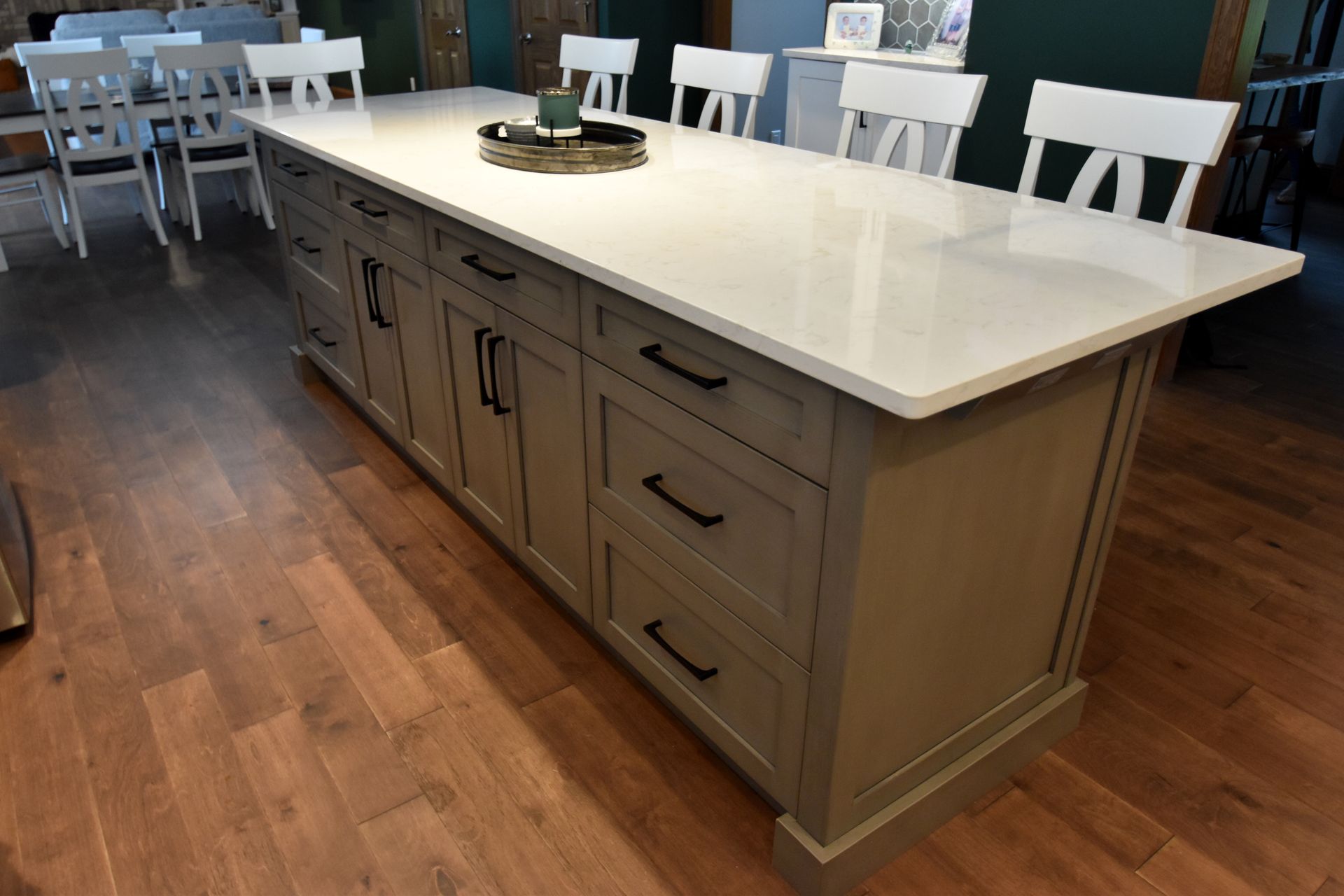 Large kitchen island with white countertop and gray cabinets in a modern dining area