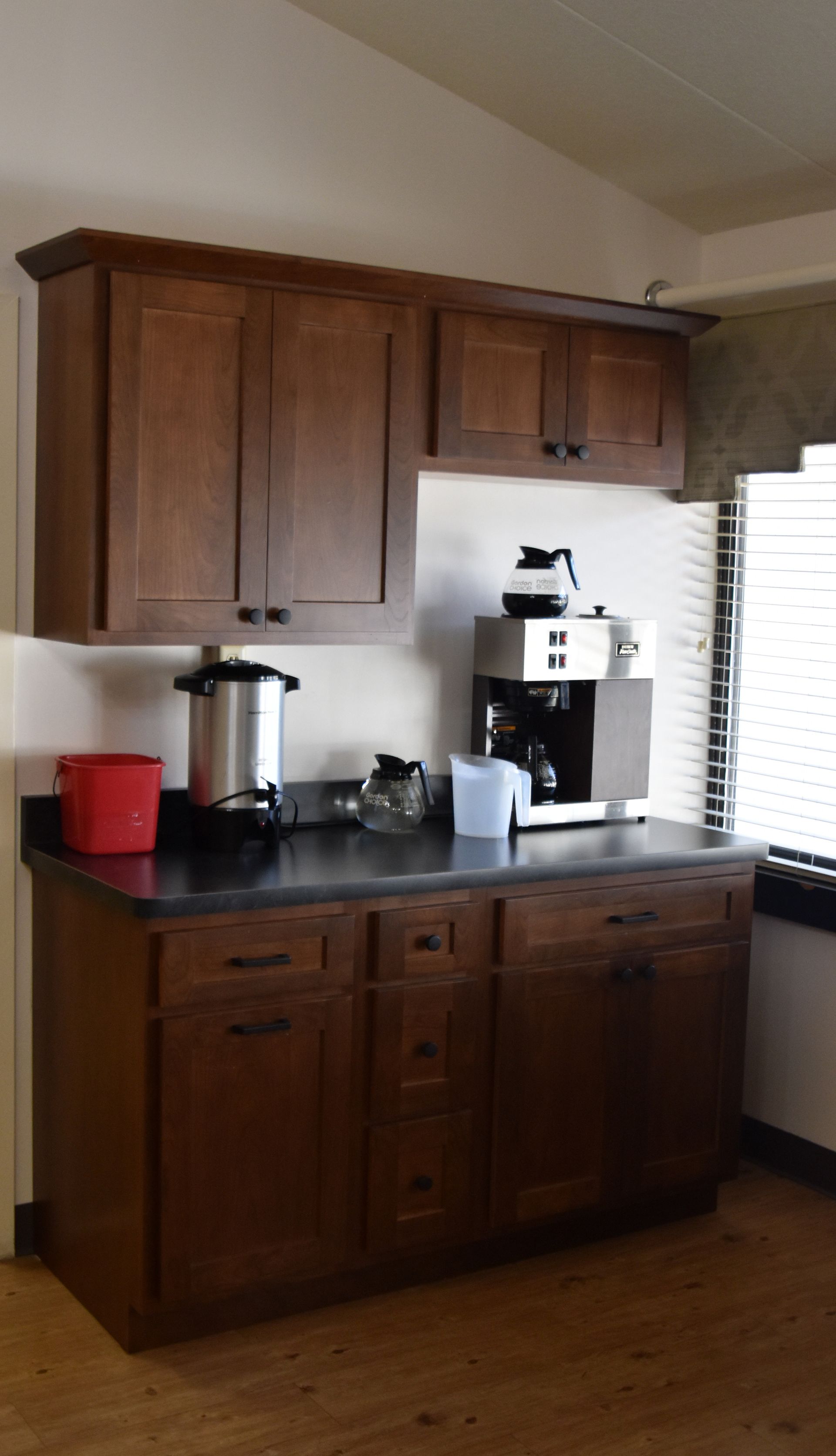 Wooden kitchen cabinets with countertop appliances in a home kitchen
