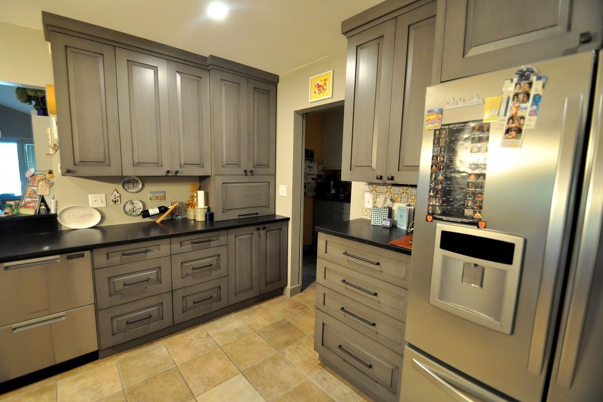 Modern kitchen with gray cabinets, stainless steel appliances, and tiled floor
