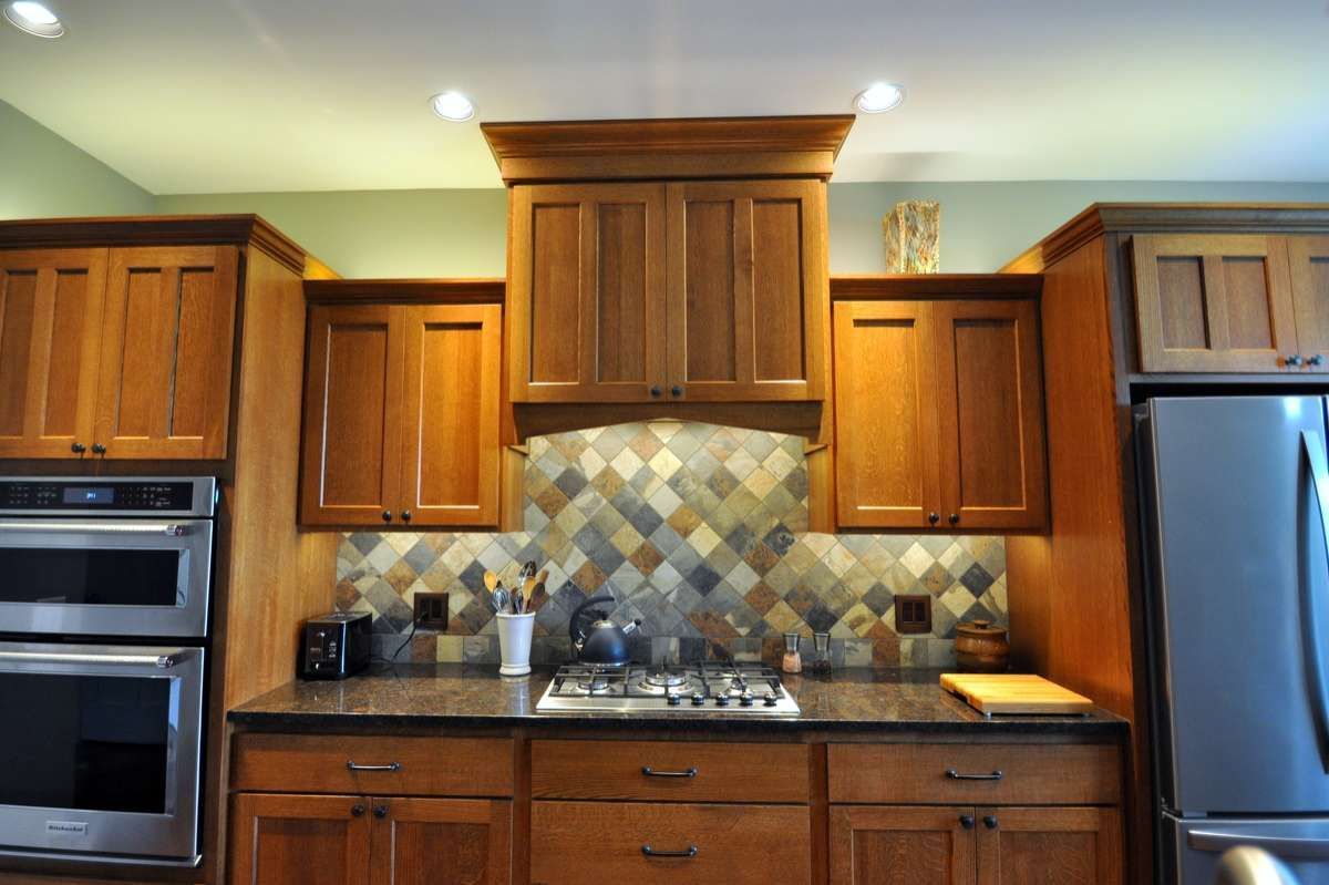 Modern kitchen with wooden cabinets, stainless appliances, and a tiled backsplash