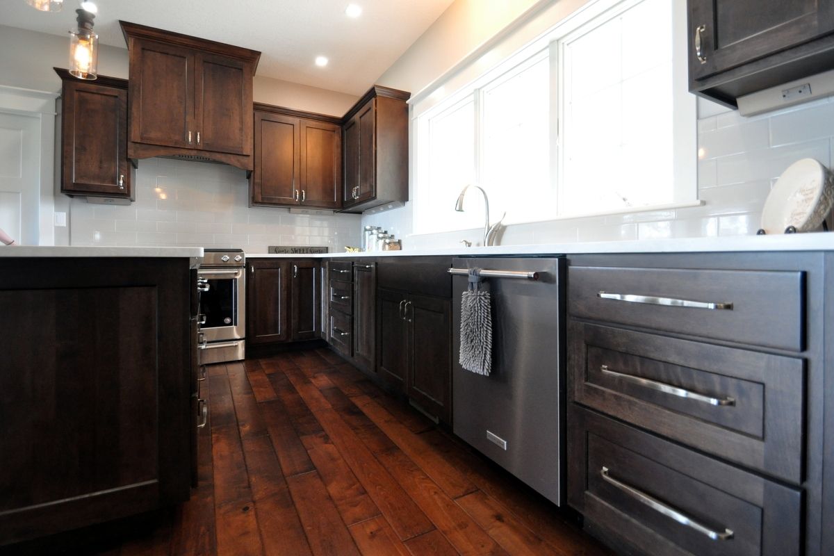 Modern kitchen with dark wood cabinets, stainless steel appliances, and hardwood floors