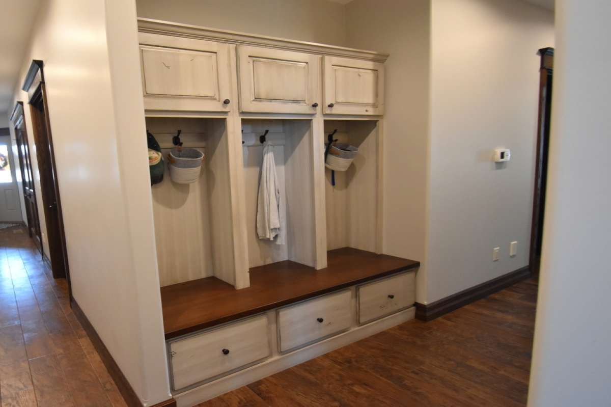 Built-in hallway storage bench with cabinets, hooks, and drawers in a home interior
