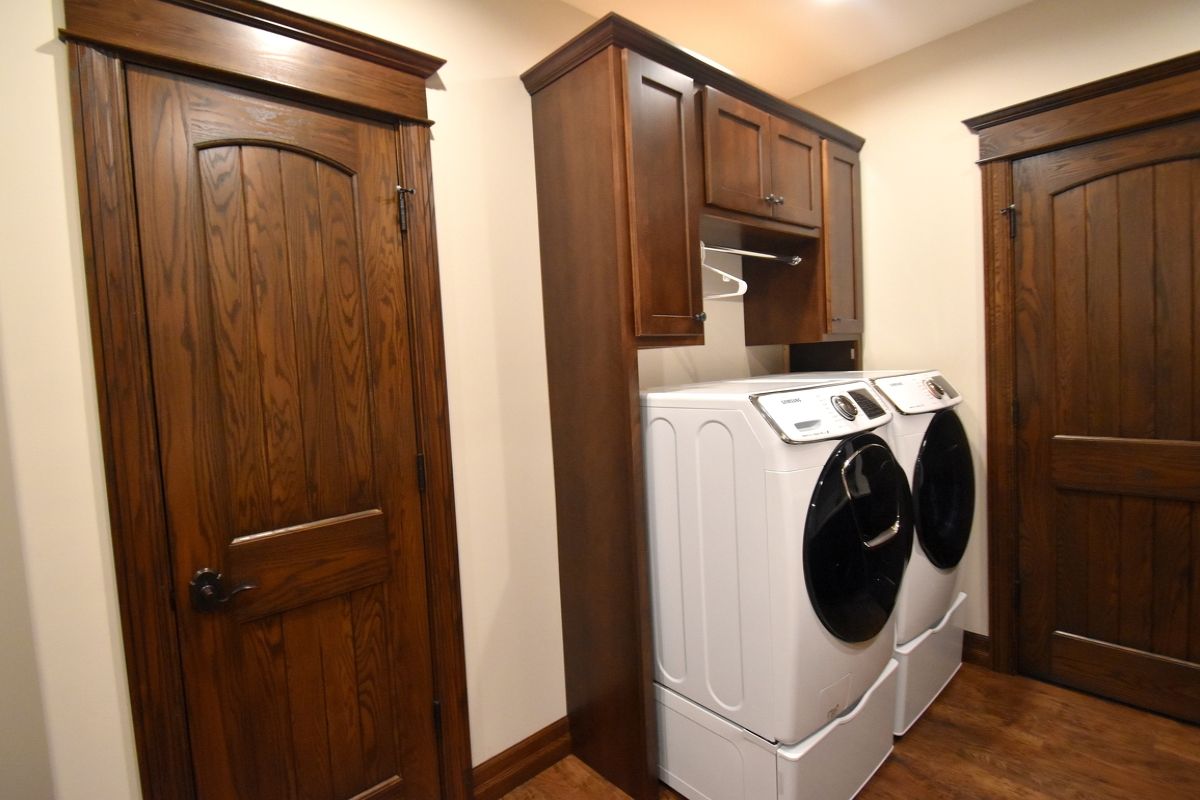 Laundry room with wood cabinets and a white washer and dryer under a counter