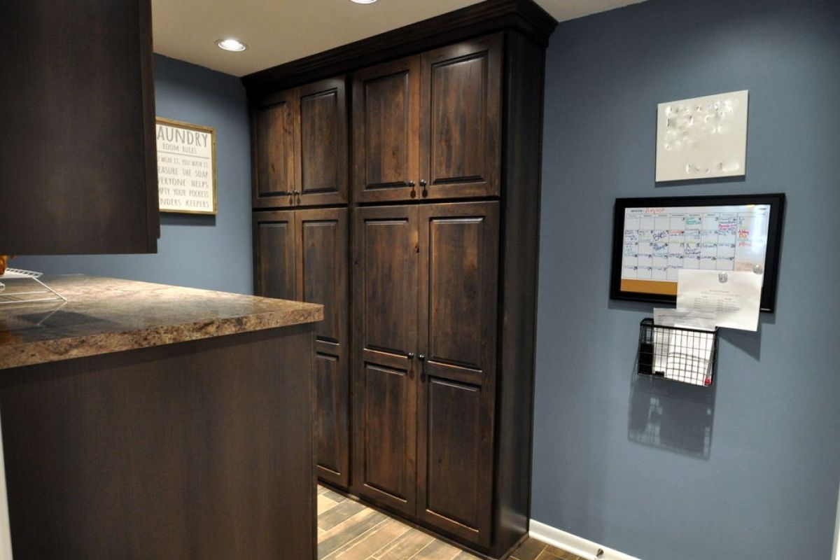Kitchen nook with dark wood cabinets, blue-gray walls, granite counter, and framed wall decor