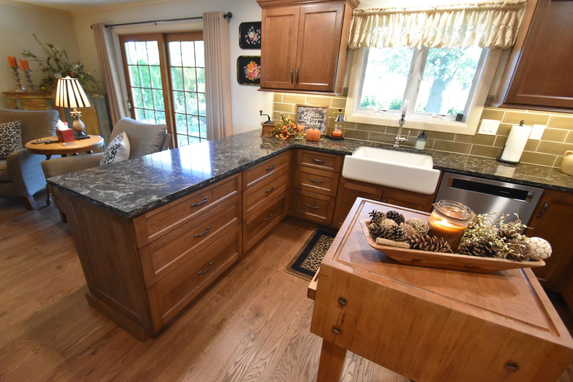 Bright kitchen with granite island, wood cabinets, and a window over the sink.