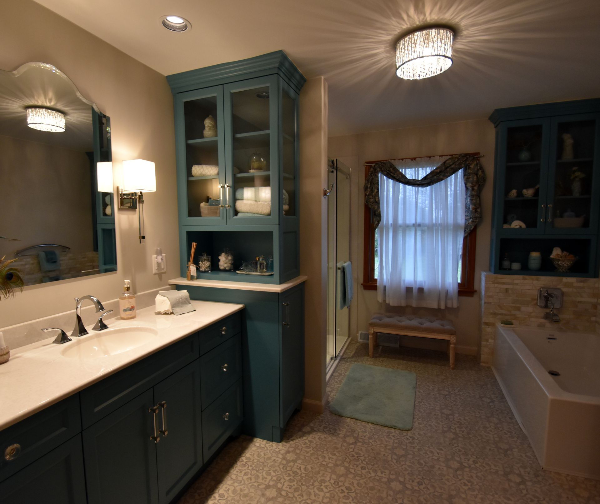 Teal-and-white bathroom with double vanity, tub, and window seat with sheer curtains