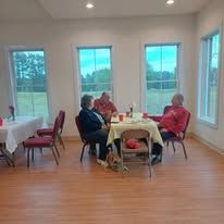 A group of people are sitting around a table in a room.