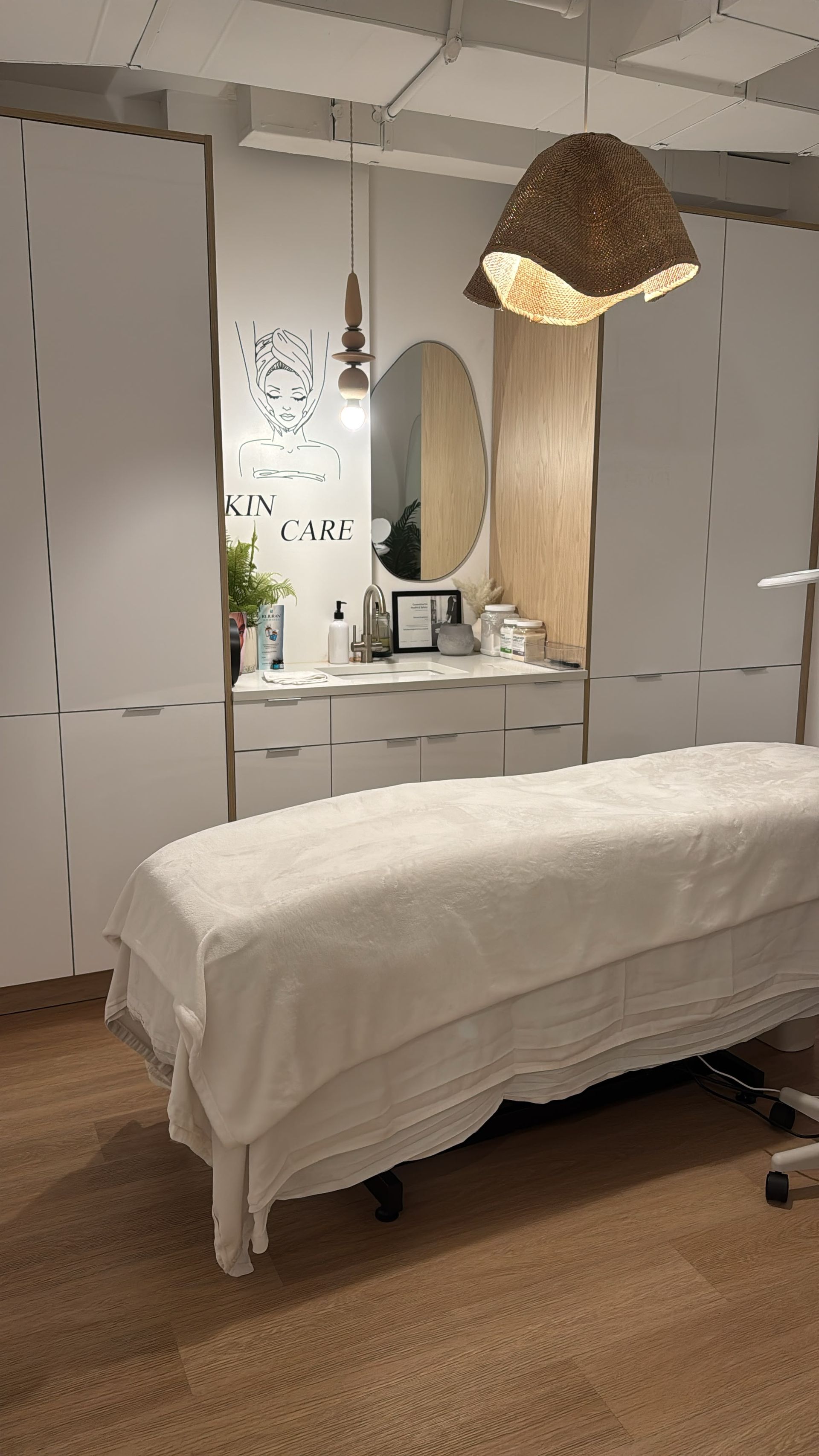 The treatment bed beside the sink and wood-front cabinet