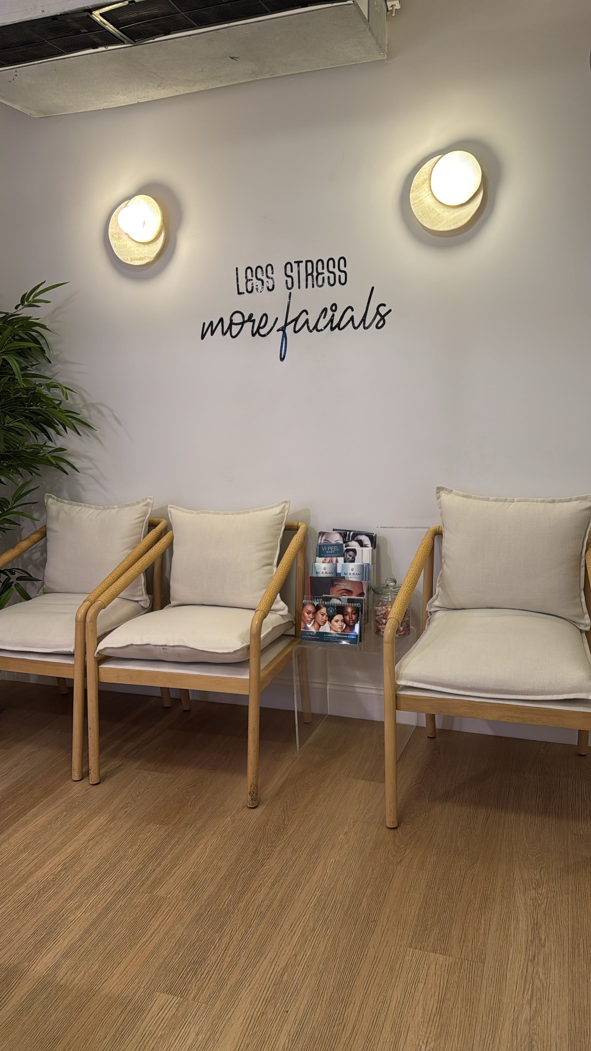 Rattan waiting chairs below the Less stress more facials wall lettering