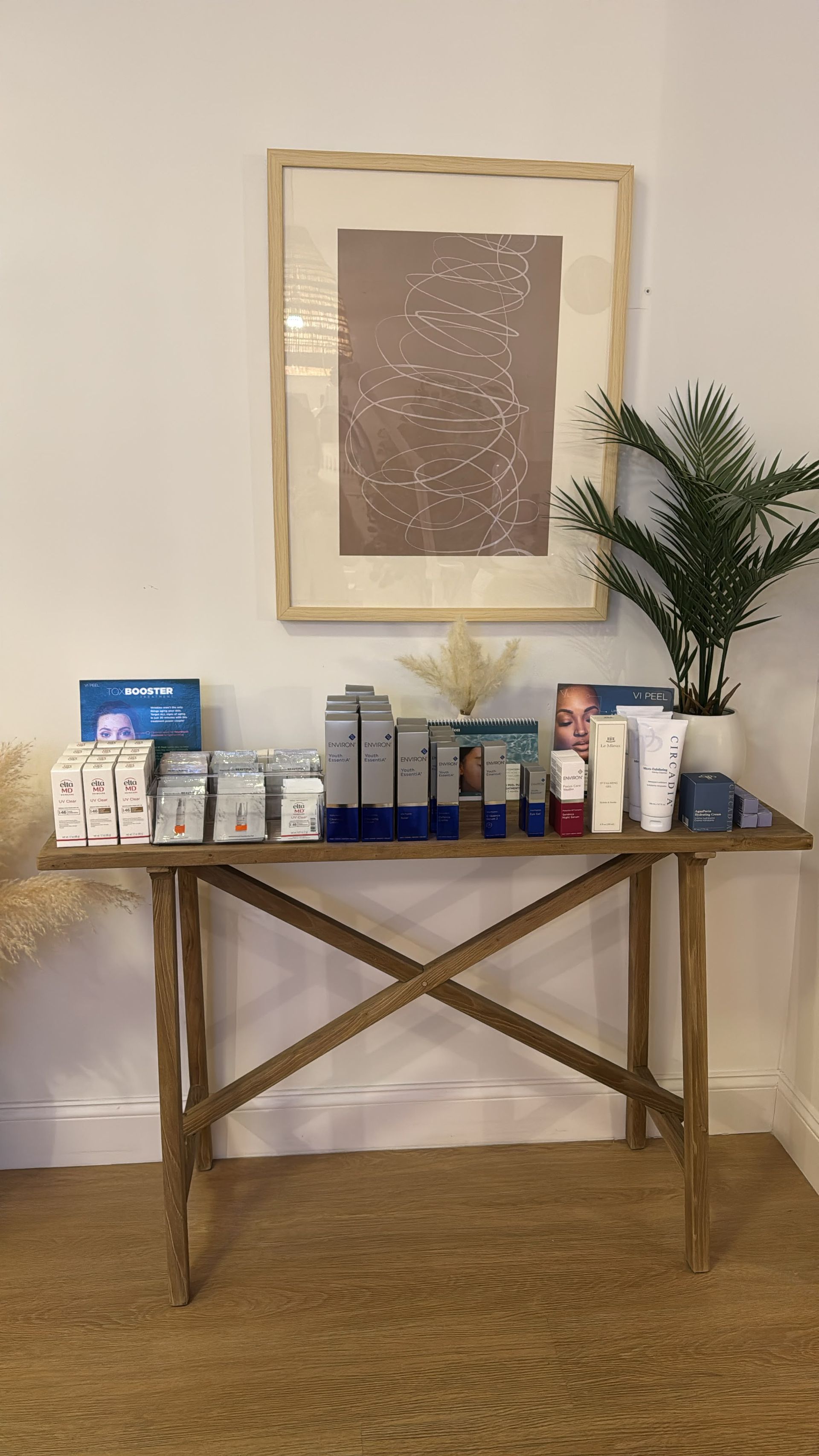 Skincare products displayed on the studio's wood console table
