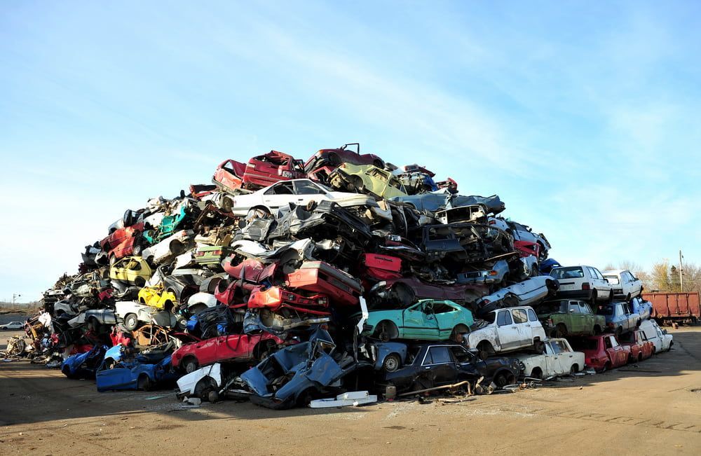 A Large Pile Of Cars Is Sitting On Top Of Each Other In A Scrap Yard — Caloundra Scrap Metal in Maleny, QLD