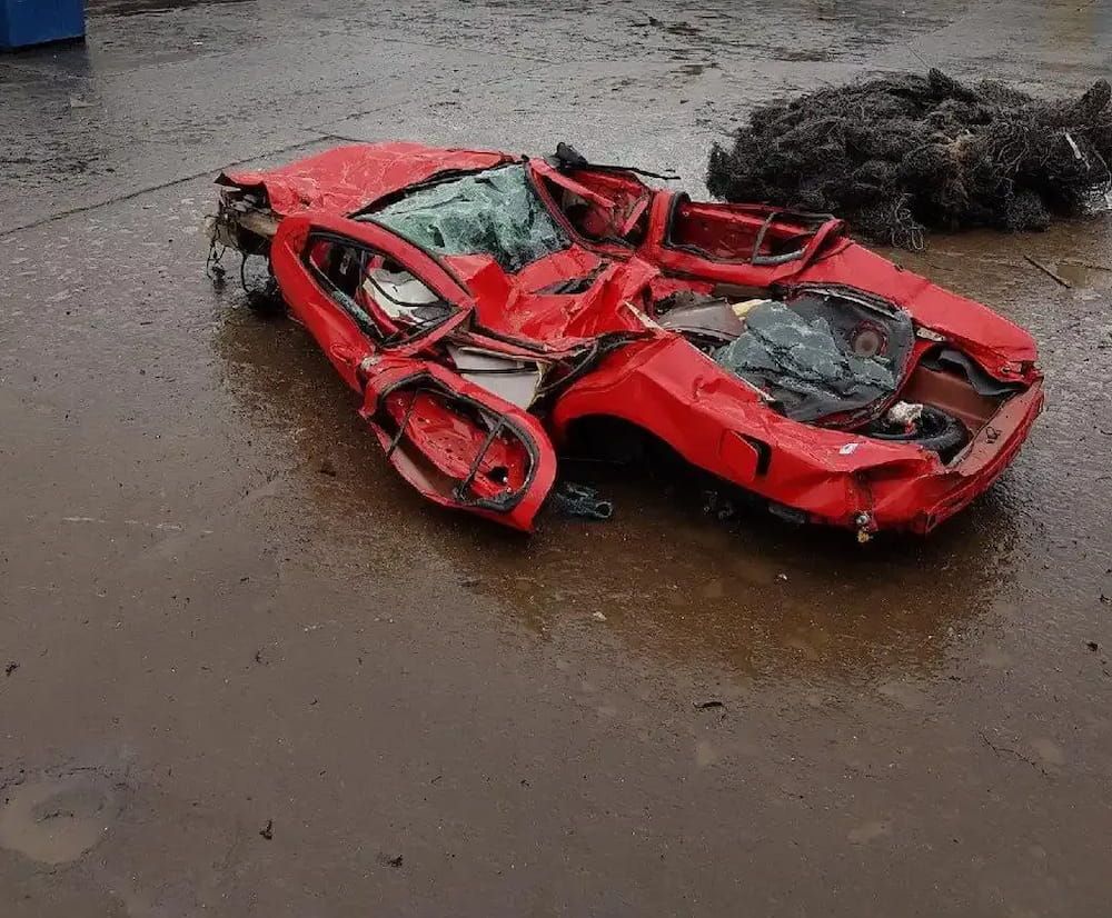 A Wrecked Red Car Is Laying In The Mud — Caloundra Scrap Metal in Landsborough, QLD
