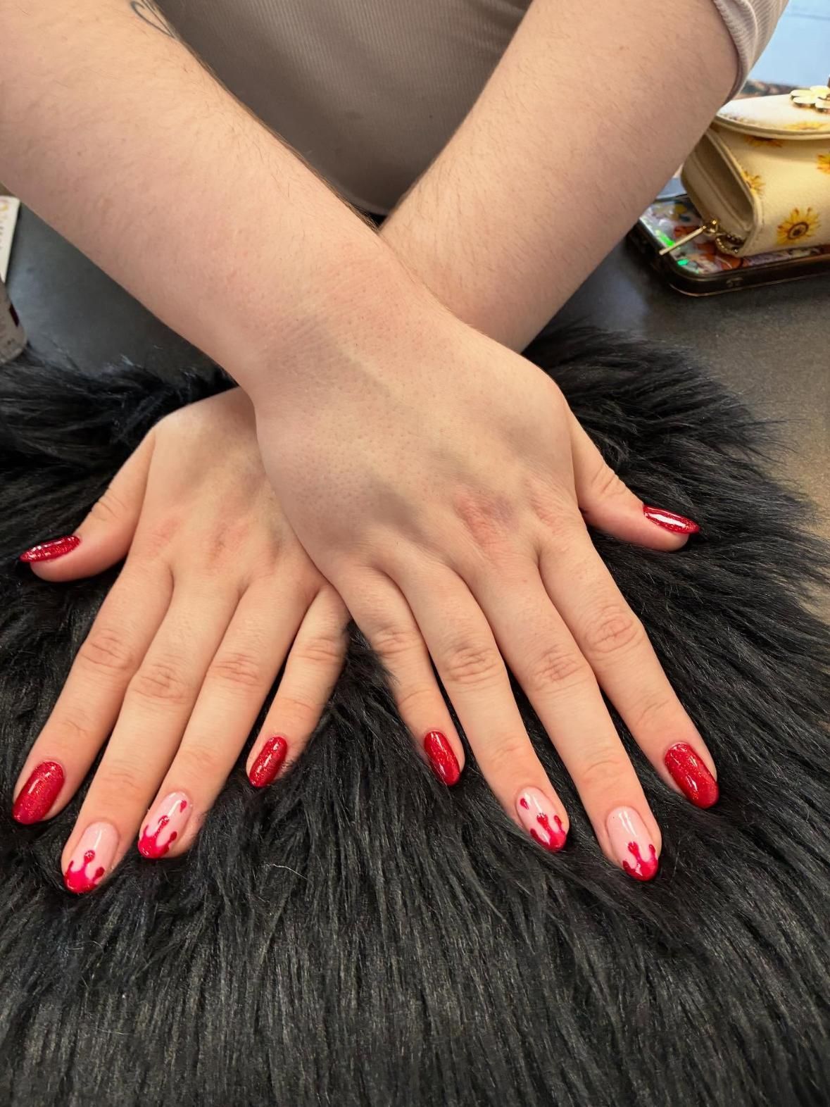 Hands with red nail polish, some with dripping blood design.