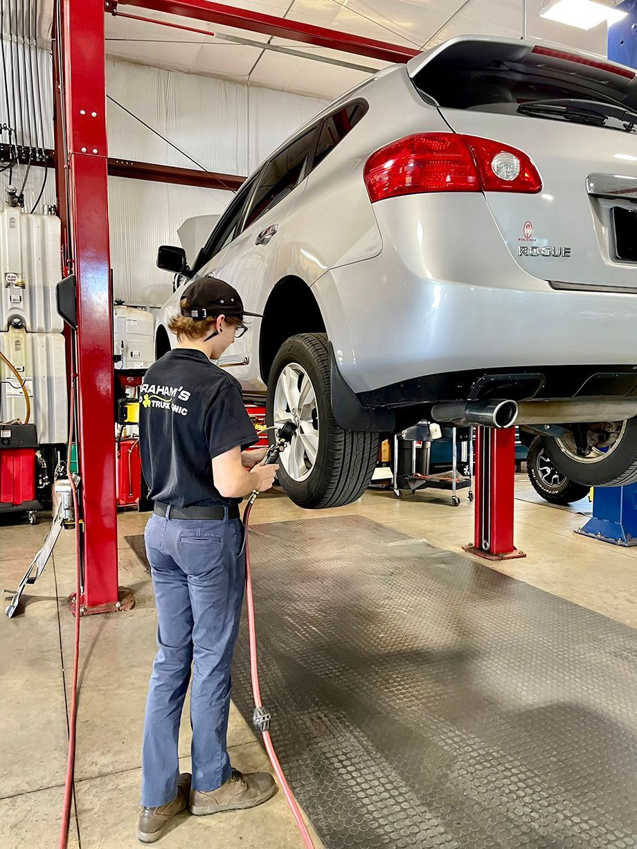 lady repairing white car | Grahams Auto & Truck Clinic