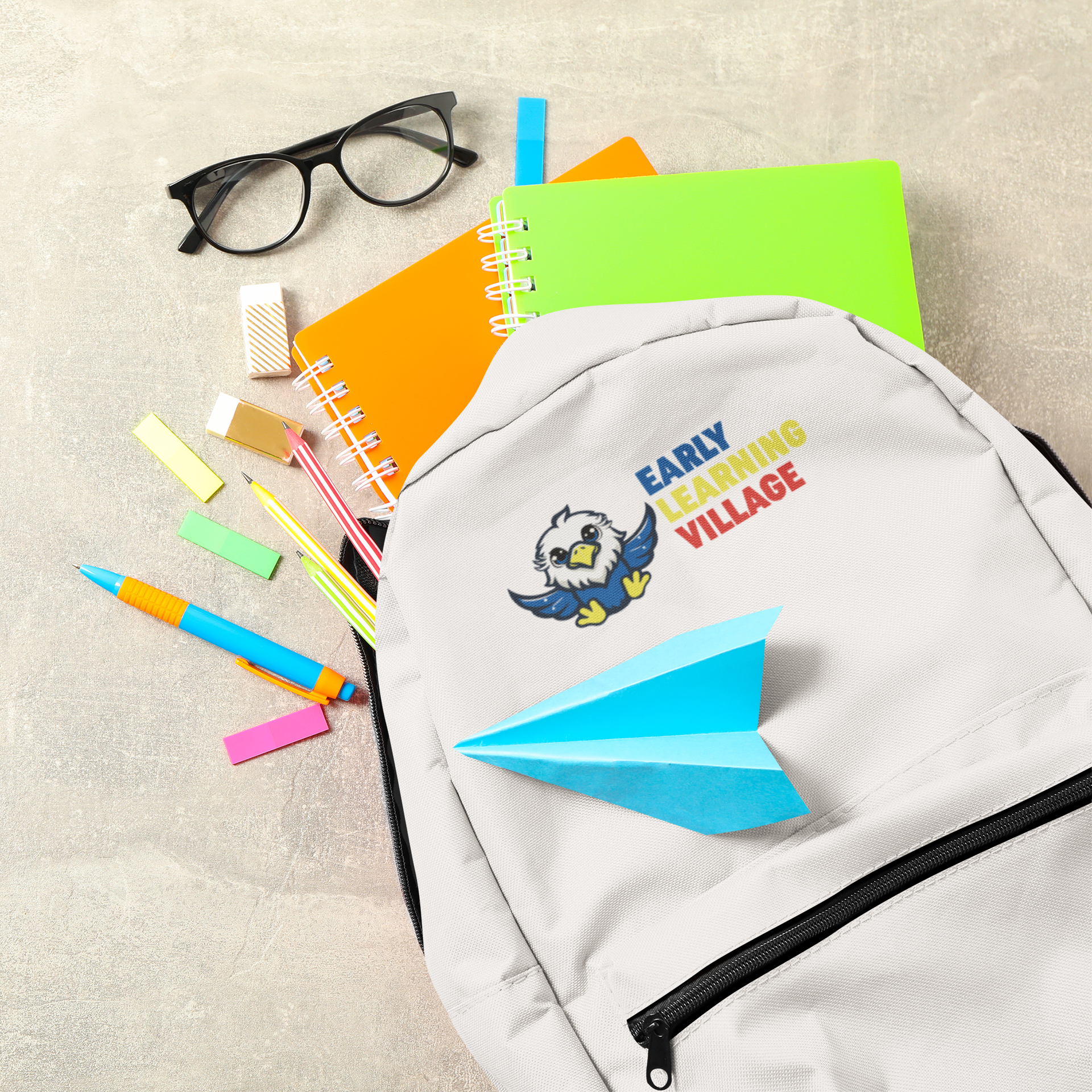 A flat-lay of school supplies including a gray backpack with an