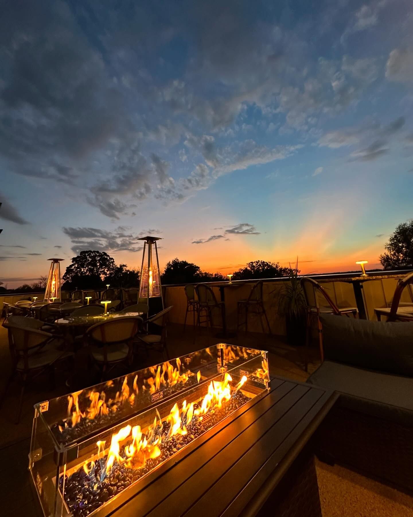 A fire pit on a table with a sunset in the background
