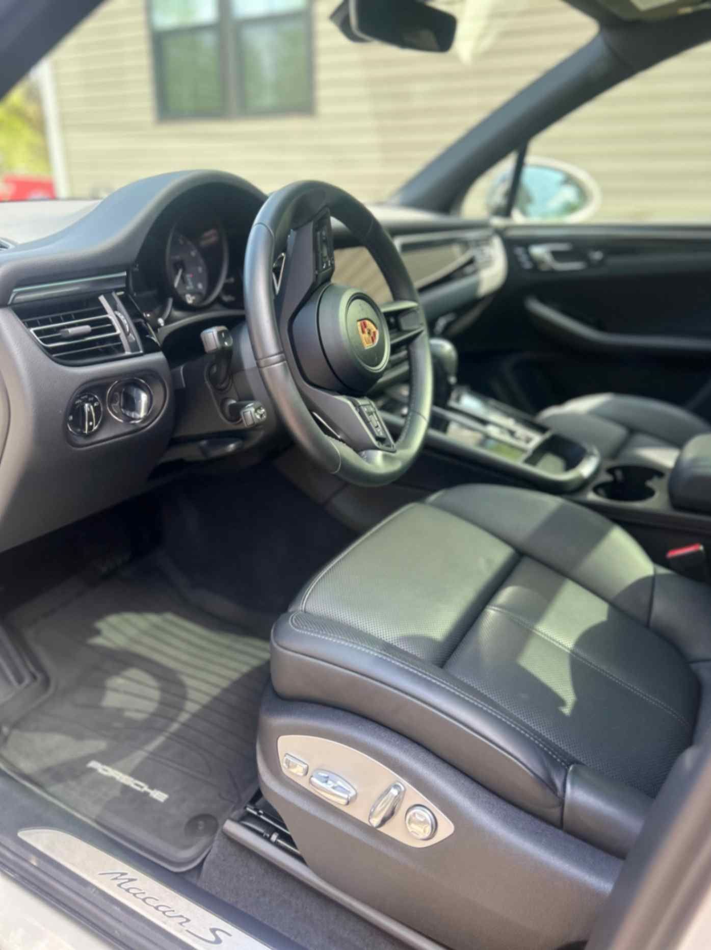 Porsche Macan black leather driver area cleaned and conditioned after interior service.