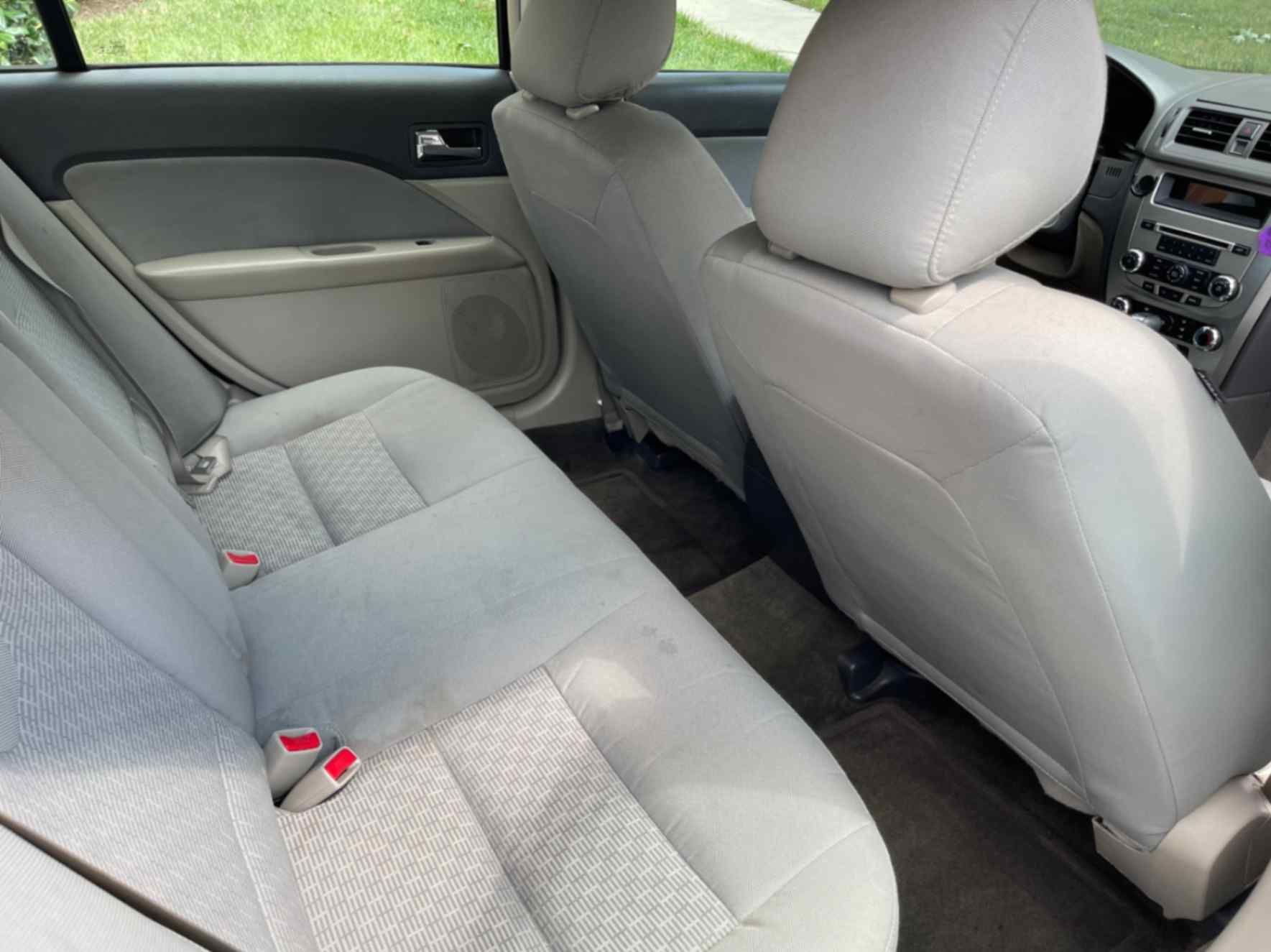 Gray cloth sedan rear seats cleaned and prepared during interior remediation work.