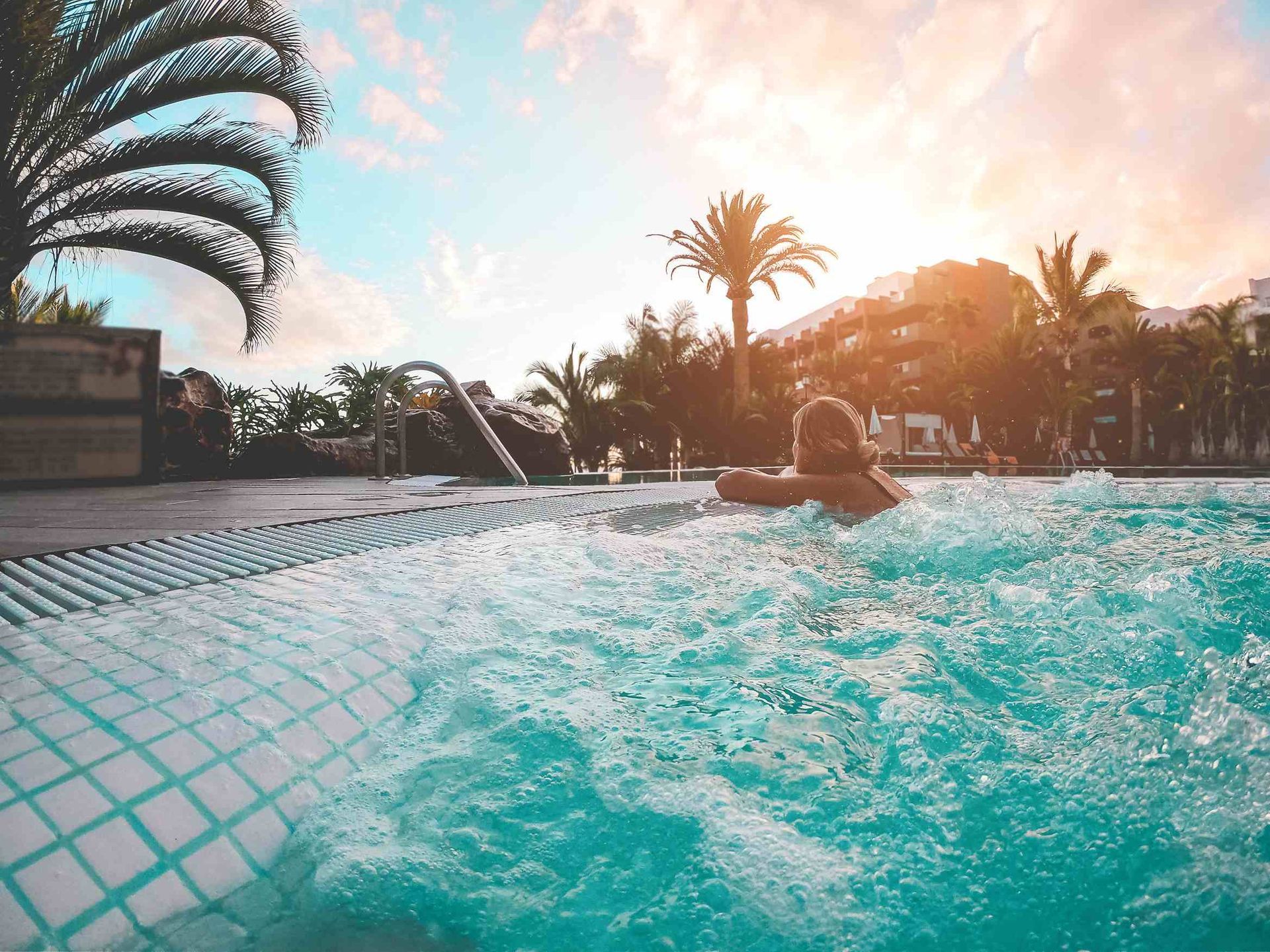 A woman relaxing in a new pool by some palm trees in North Texas