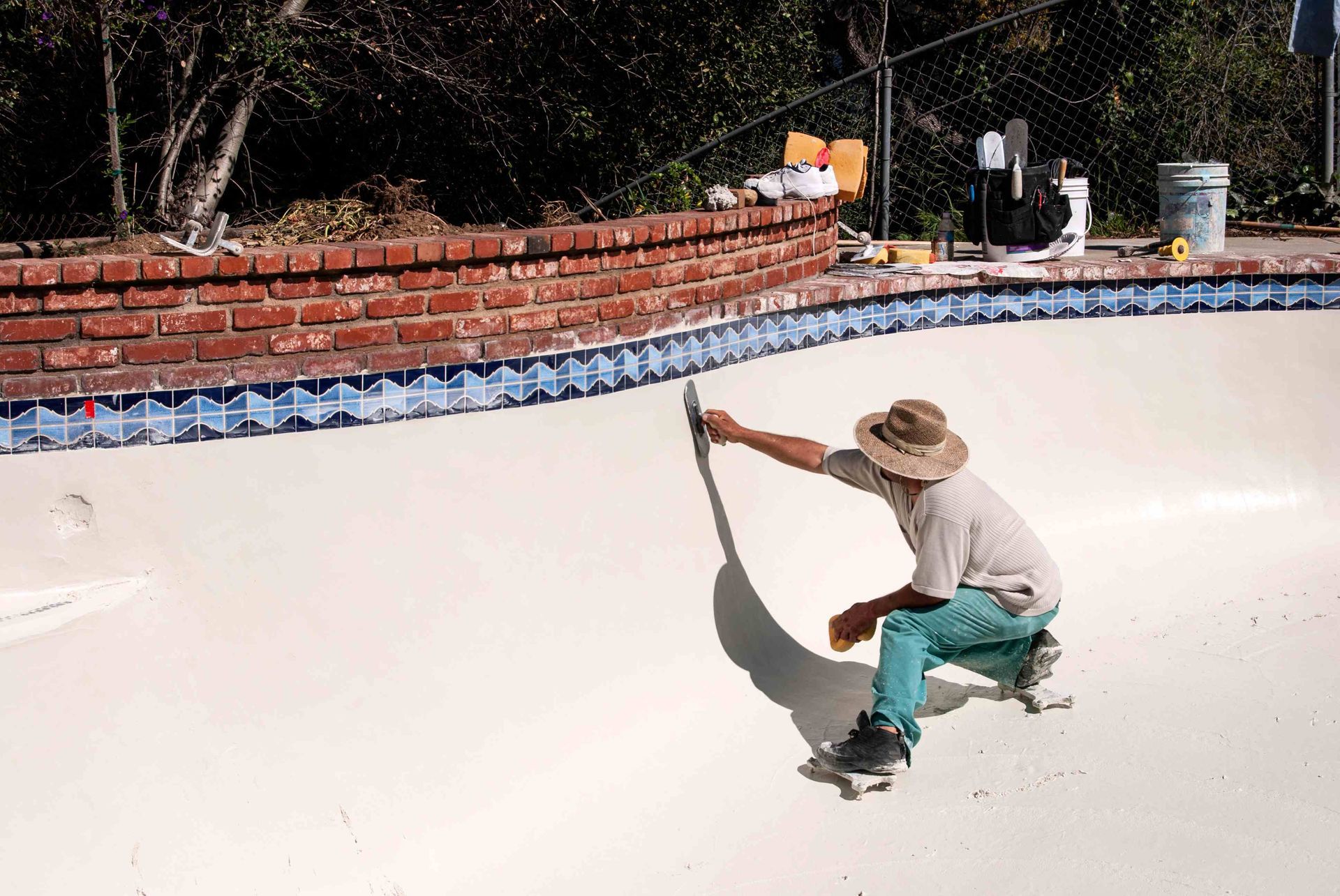 A pool builder plastering a pool