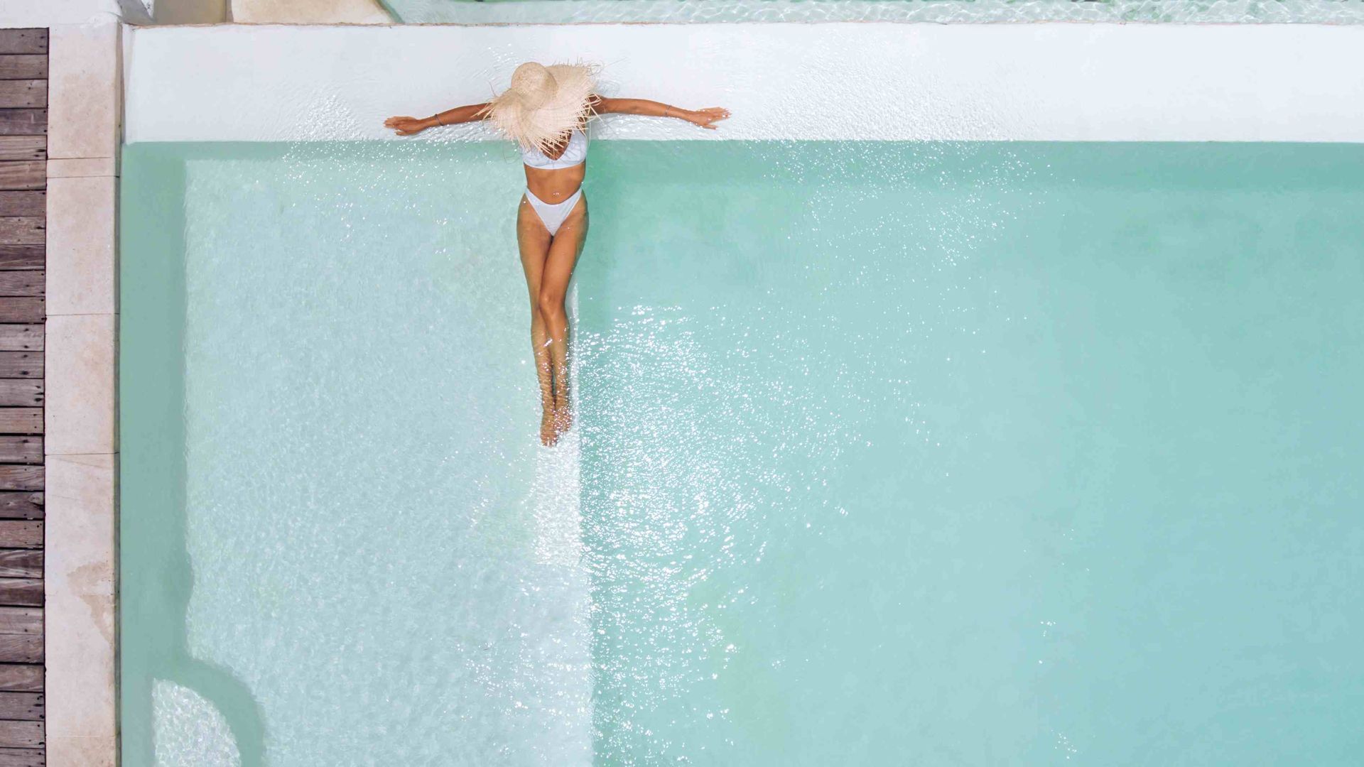 An attractive woman with a straw hat sitting in the water
