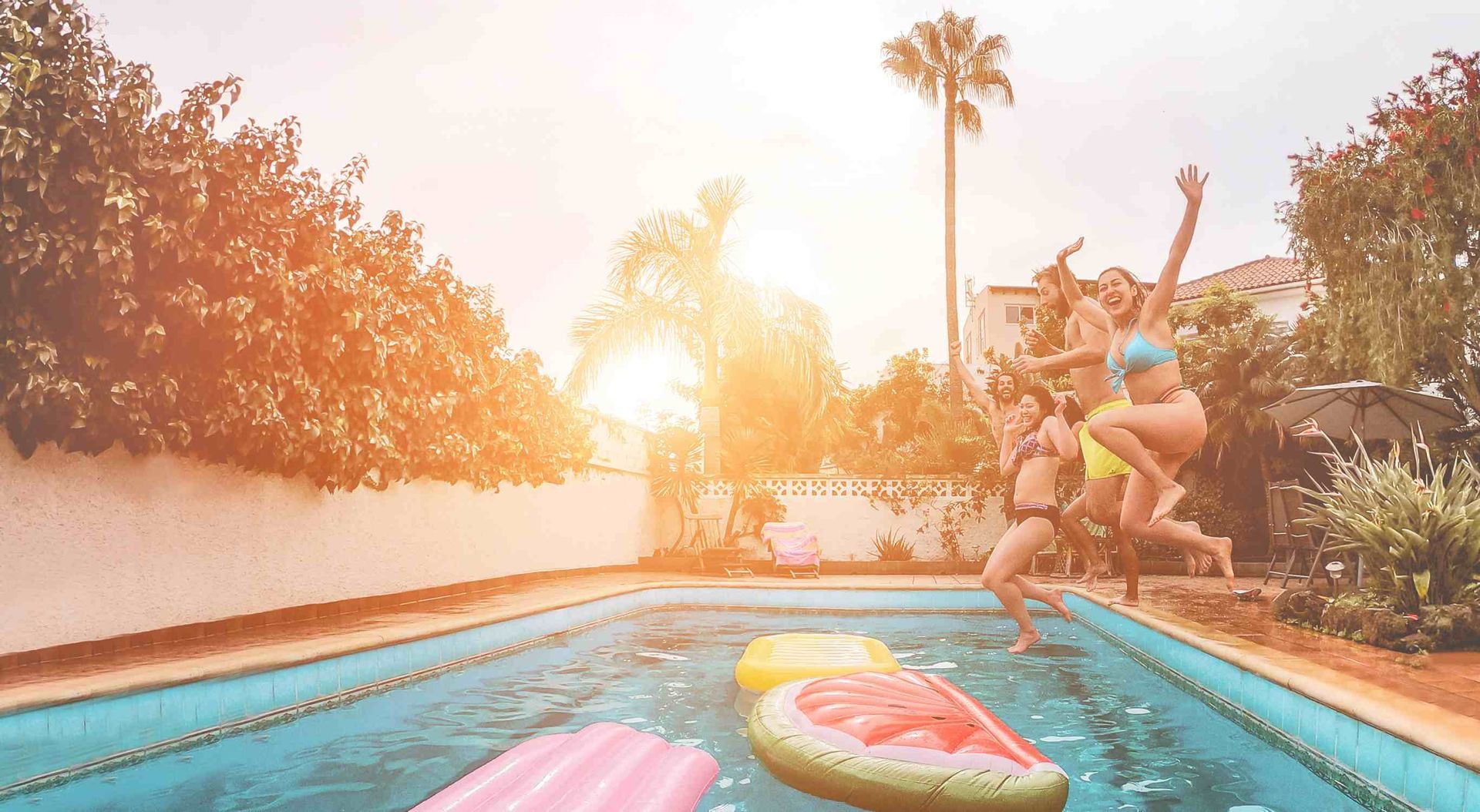 Friends all jumping into the pool at the same time