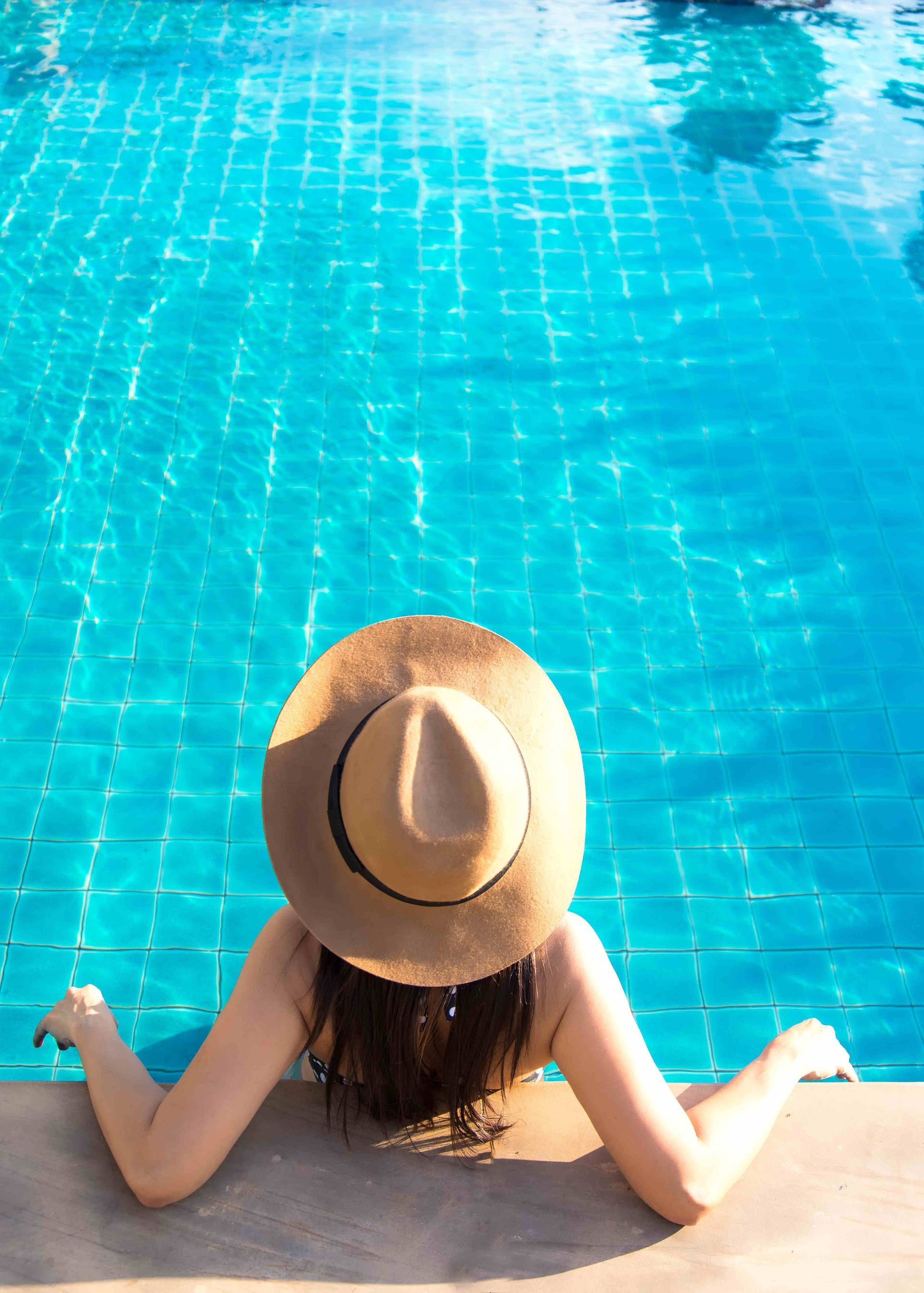Woman holding on to side of pool underwater
