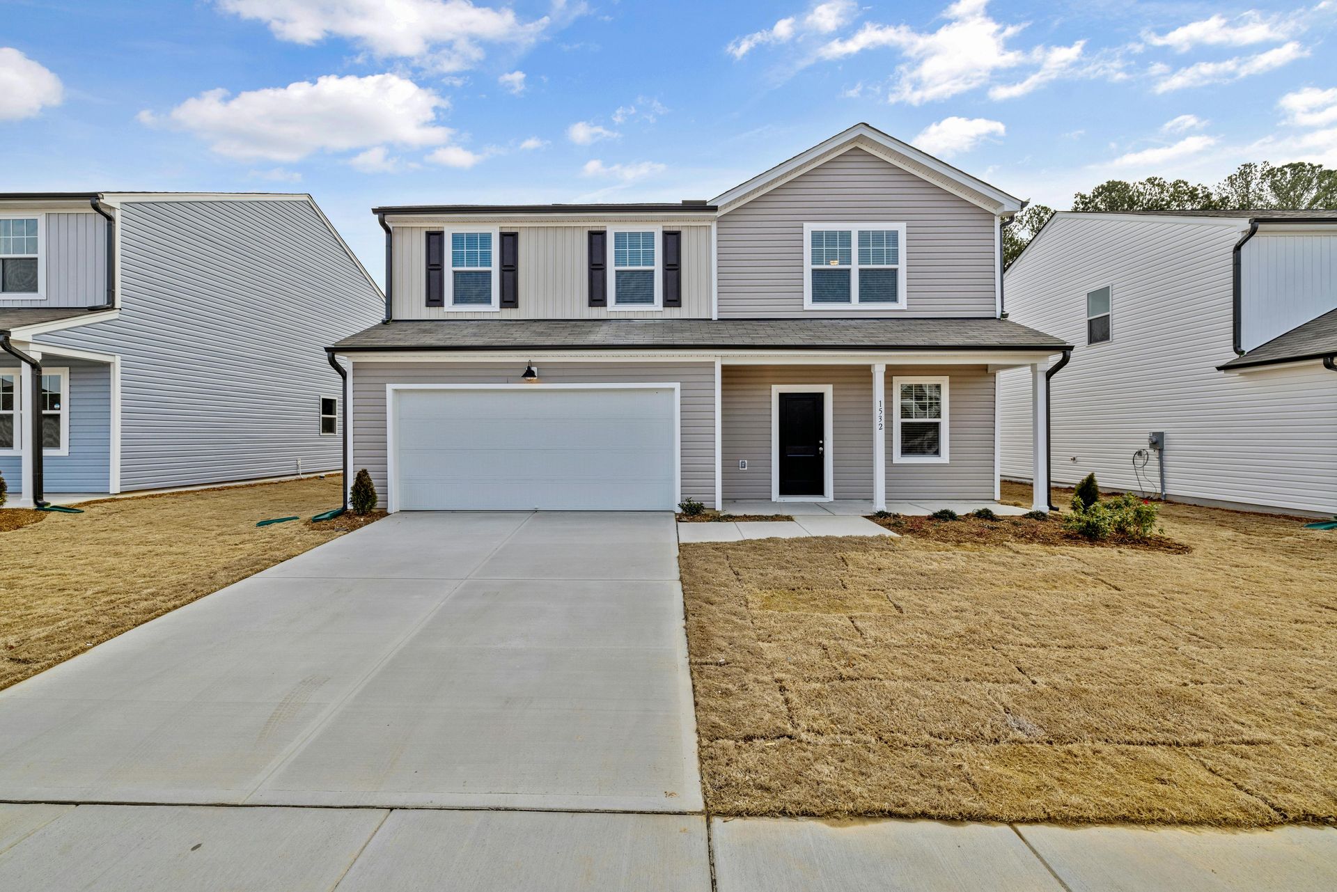 A large house with a concrete driveway in front of it.