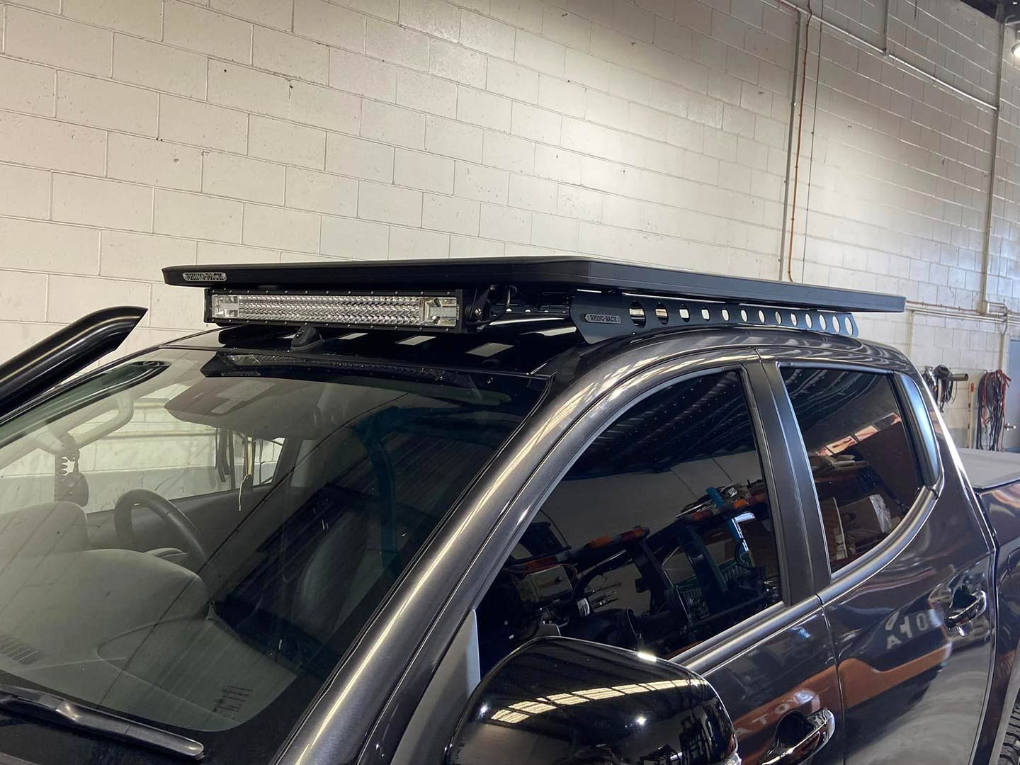 A Black Truck with A Roof Rack on Top of It Is Parked in A Garage — Motor Accessories Direct In Tweed Heads South, NSW