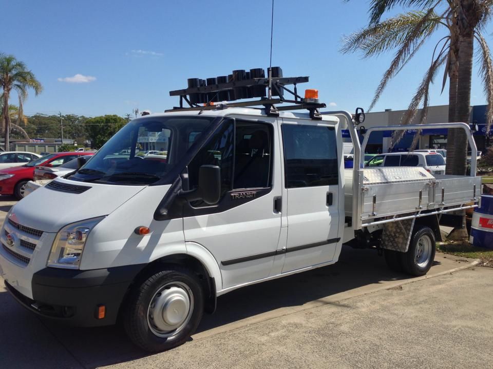 White Ford Transit Flatbed Truck With Equipment on Roof — Motor Accessories Direct In Tweed Heads, NSW