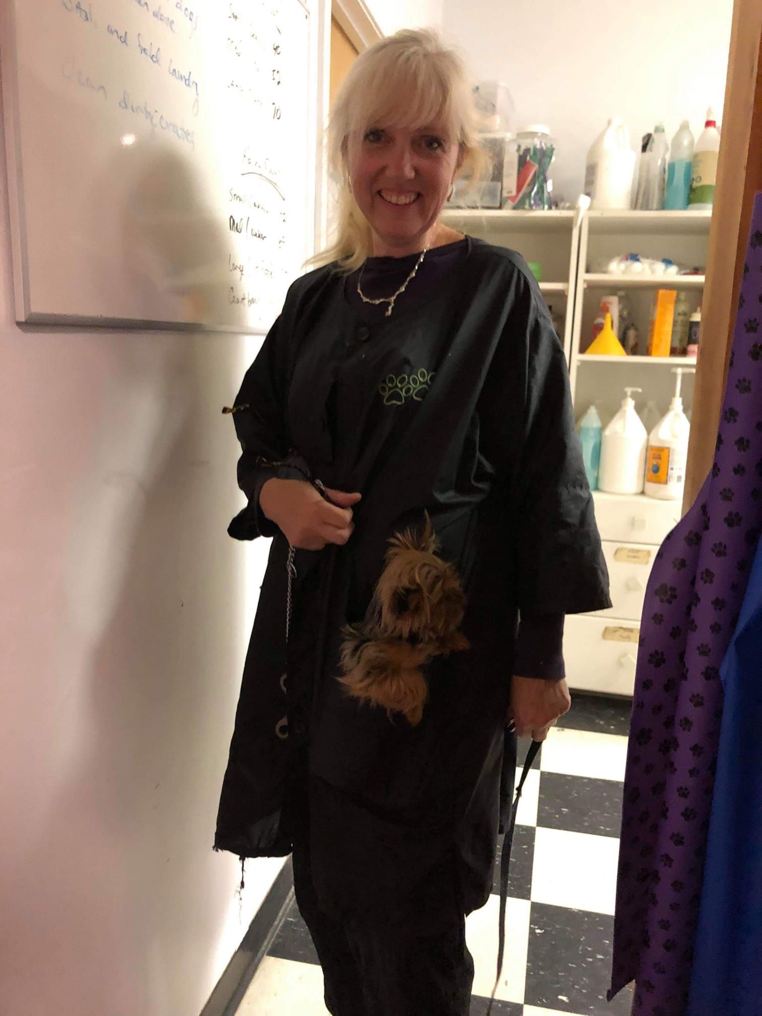 A woman wearing a black apron with a picture of a dog on it