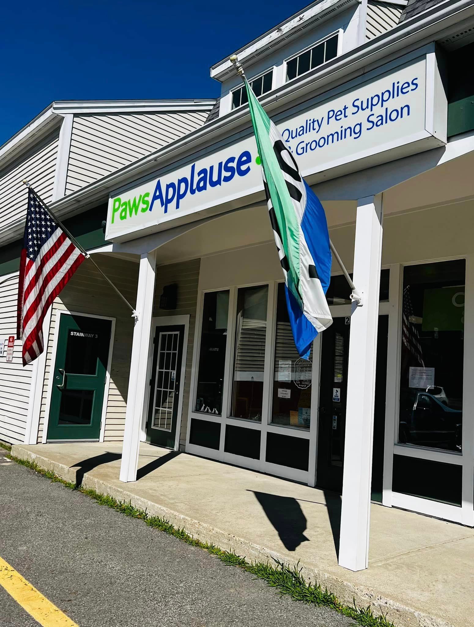 A store front with a sign that says paws applause