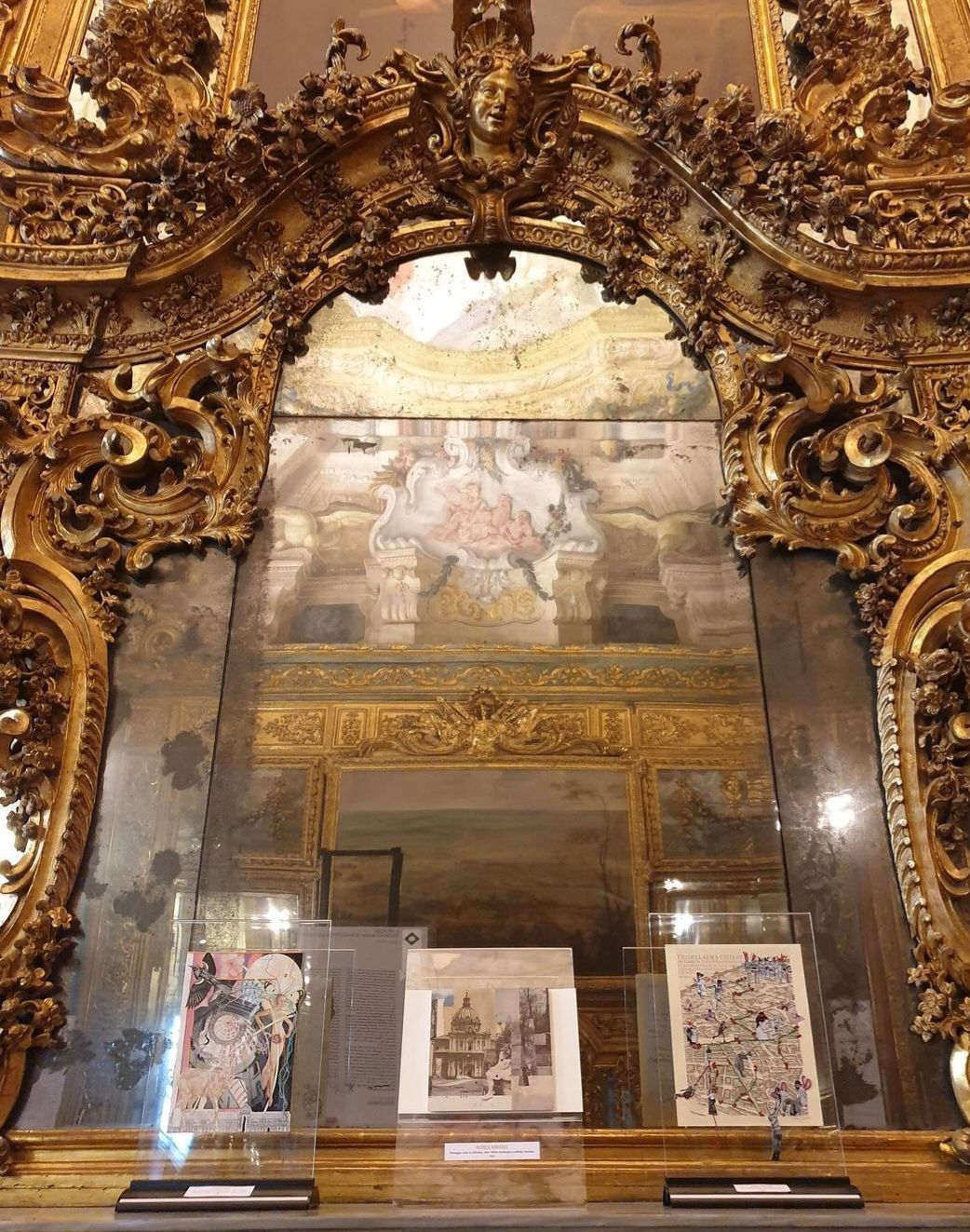 Een sierlijke, goudomlijste spiegel, die vervaagde schilderijen en tentoongestelde kunstwerken weerspiegelt.