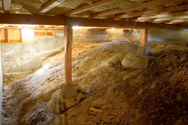 The bottom of a basement with a lot of dirt and rocks.