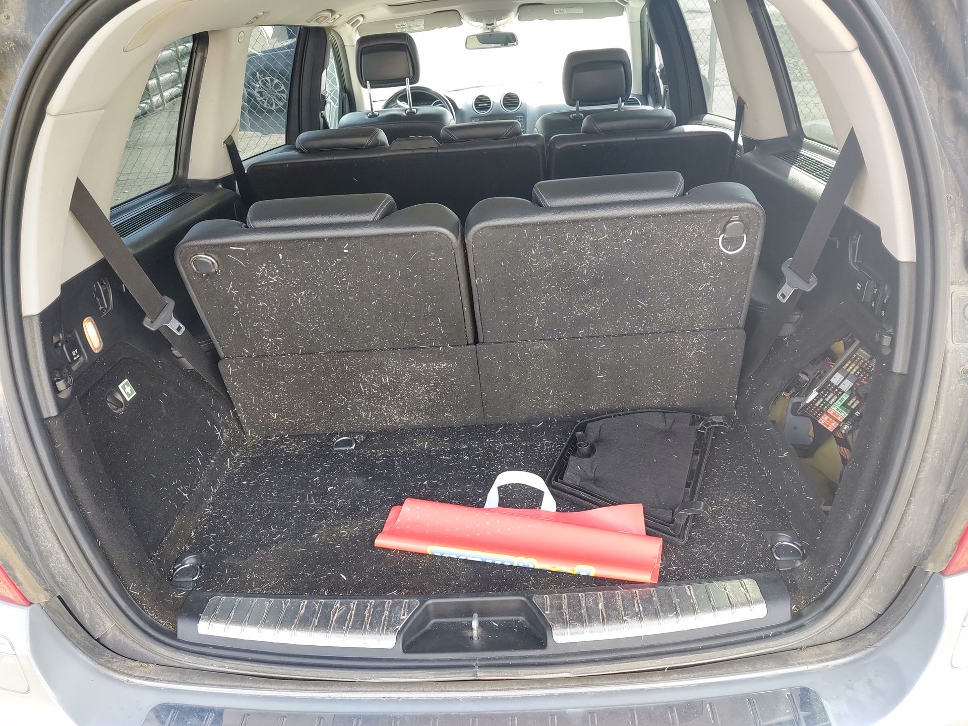 Open car trunk with rear seats folded down and a red item on the floor.