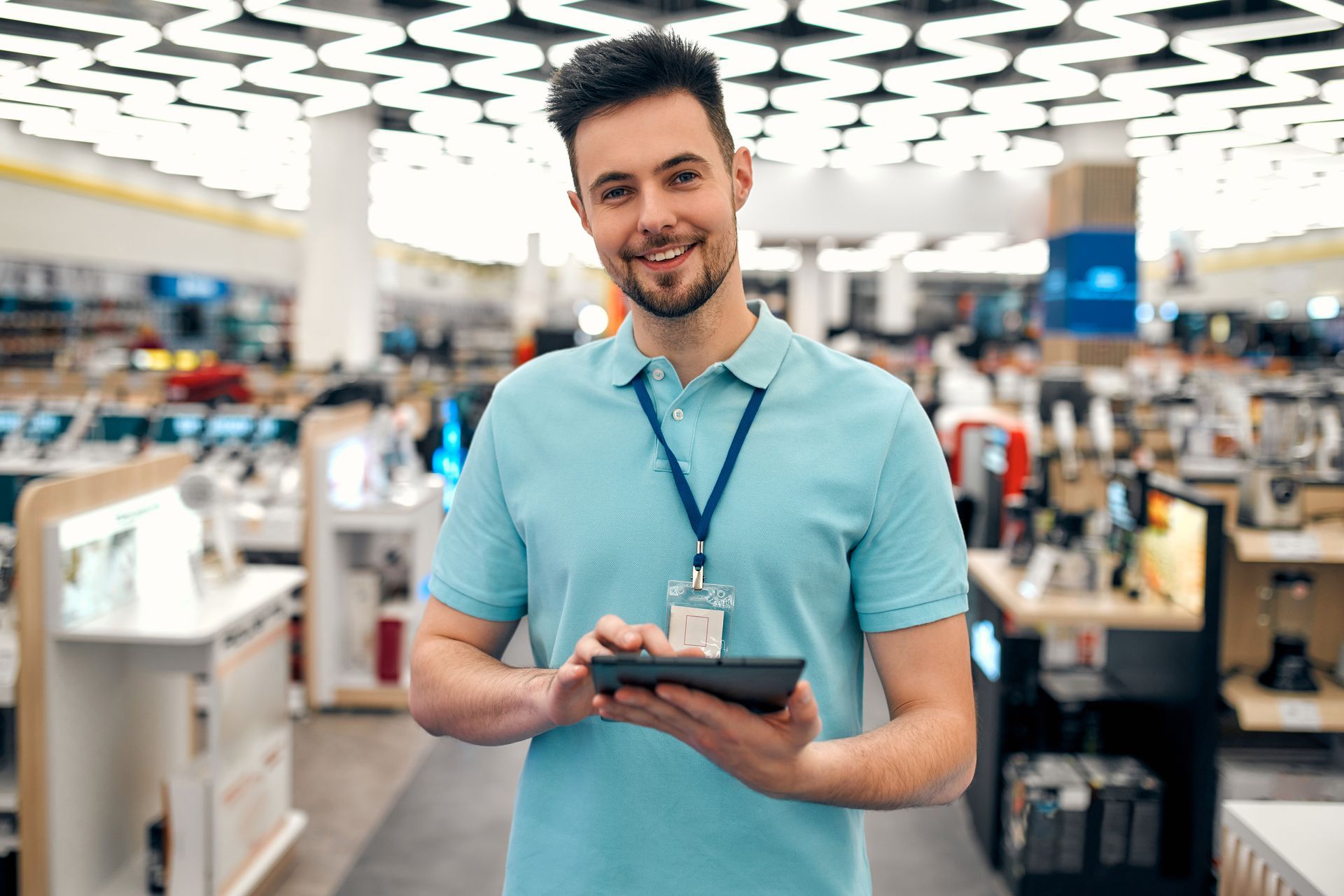 Een man houdt een tablet vast in een winkel.