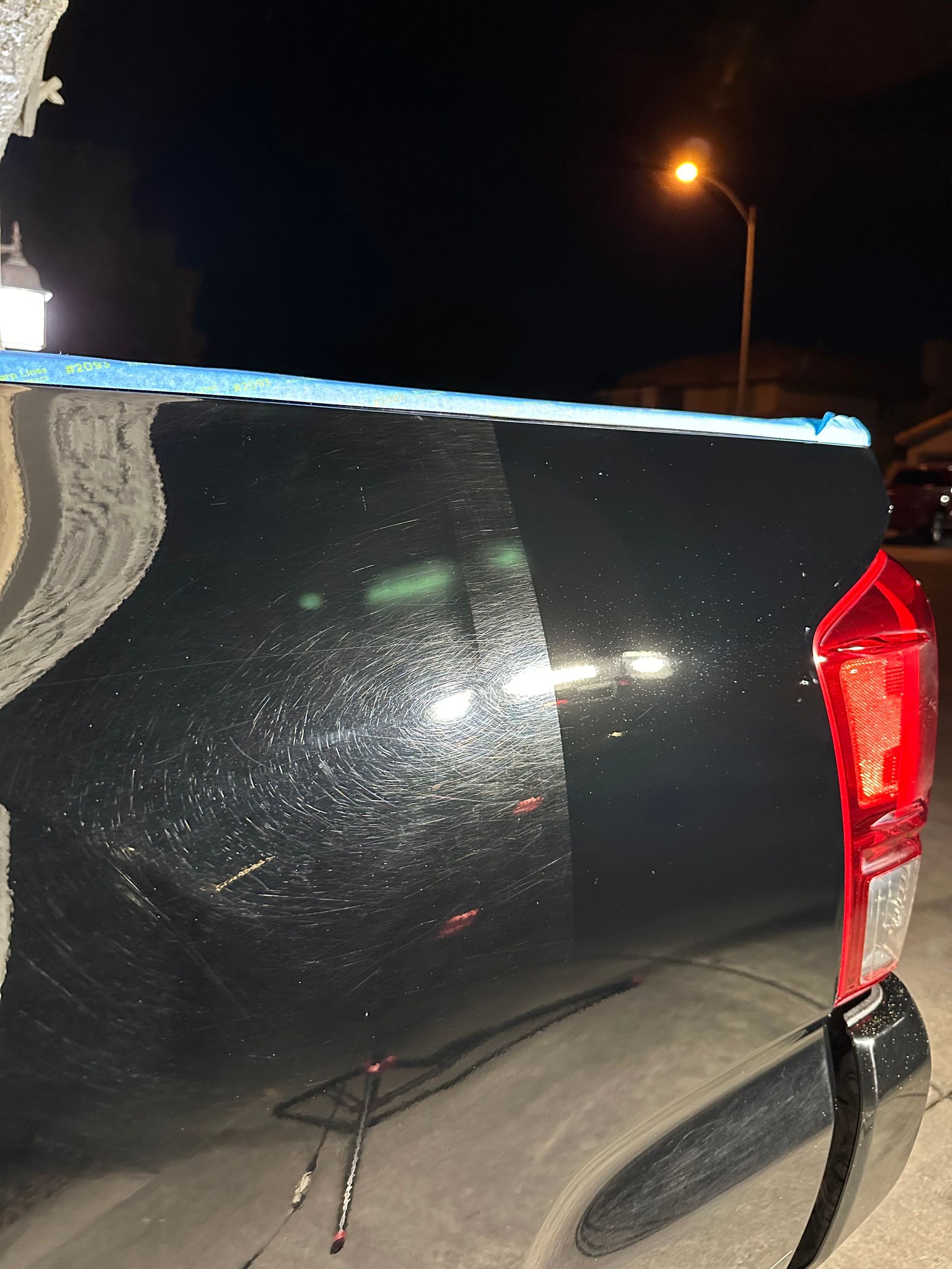 A black truck is parked on the side of the road at night