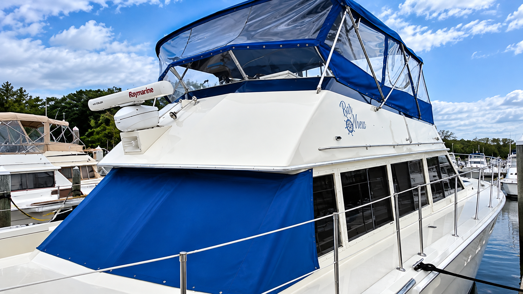 Blue-and-white yacht docked at the marina under a clear sky